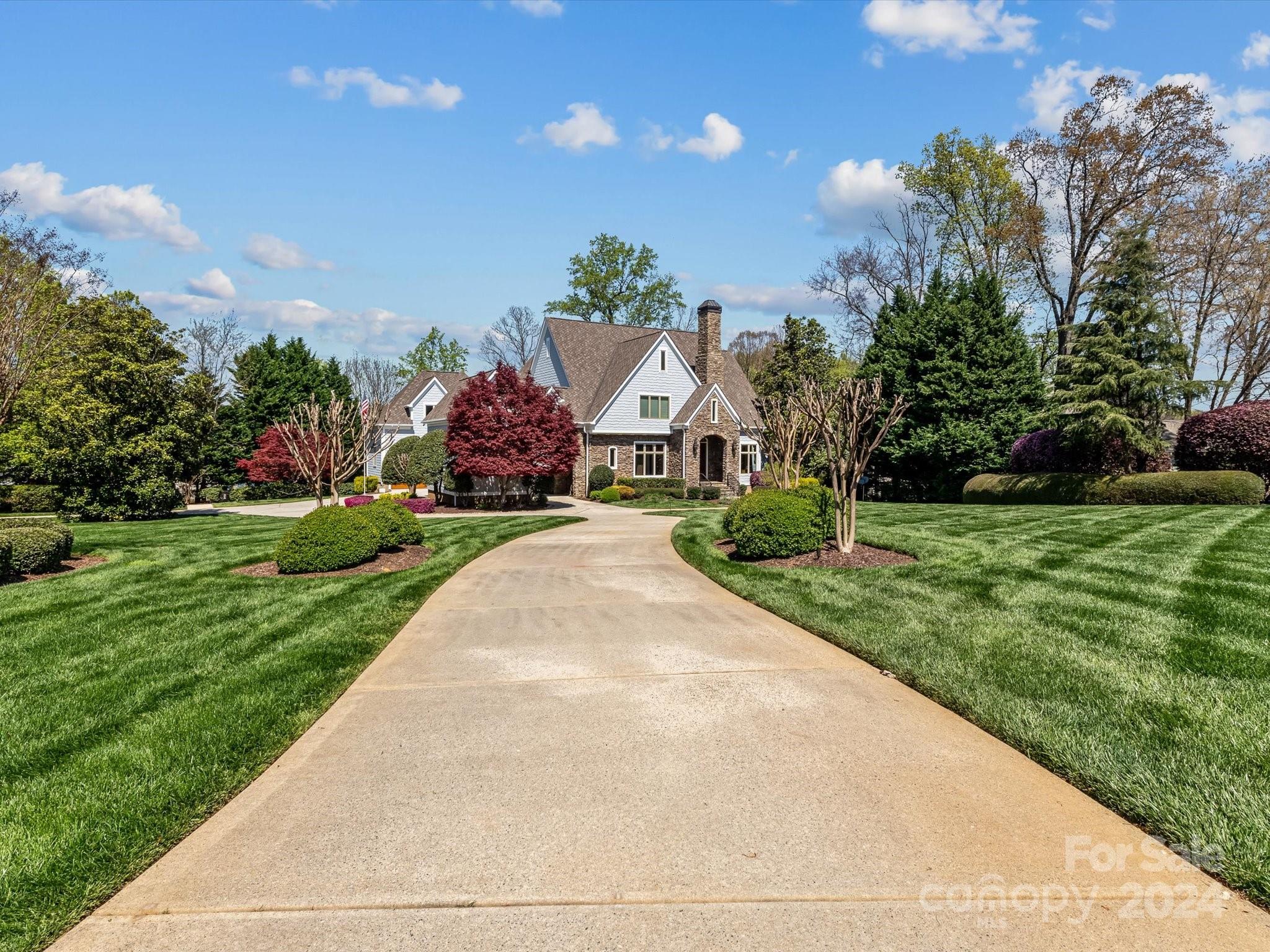 Come see this gorgeous water front home in The Point with BIG water views! This home features a well appointed primary bedroom on the main level with a formal dining room, office w/coffered ceilings and a fireplace.  The living room has a second fireplace and built-in bookcases. The large kitchen features a gas range with a hood, double wall ovens, microwave built-in to the island and ample storage!  The elevator will lead you to the basement with a second living quarter with a full kitchen, second primary bedroom, with an ensuite with a shower and soaking tub. The second living quarters also has as living room, dining room, office and powder room.  Upstairs has three additional bedrooms and 3 additional full baths as well as a bonus room w/a third fireplace and rec room.  Outside you can enjoy the water views from the beautiful pool! There are also multiple porches, balconies & patios! There are too many features to list, this home must be seen to fully appreciate all it has to offer!