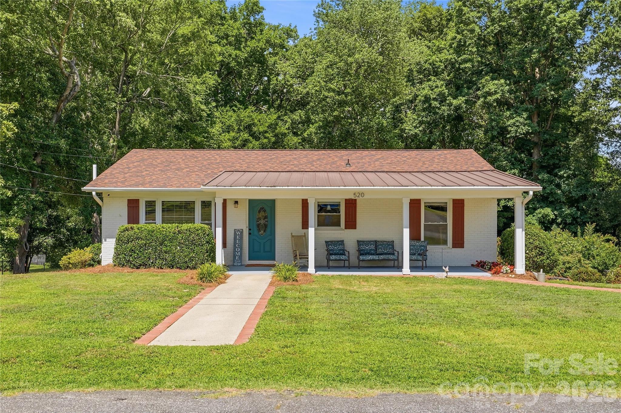 Welcome to this charming brick ranch nestled on a spacious lot in the revitalized and growing Kannapolis area! This 3-bedroom, 2-bath home offers the perfect blend of character, comfort, and convenience, located less than 10 minutes from downtown Kannapolis, I-85, shopping, dining, and endless local amenities.

Step onto the newly added covered front porch and into a warm, inviting living room filled with natural light. A full home CPI security system control panel will be directly to your left when entering. Hardwood and tile flooring throughout complement the functional layout designed for everyday living. The primary suite features a private en-suite bathroom and direct access to a large deck, creating the perfect space to enjoy your morning coffee or unwind after a long day.

Two additional bedrooms provide flexibility for family, guests, or a home office. The centrally located hall bathroom includes a tub/shower combination for added convenience. The dining area flows seamlessly into the kitchen, which features updated cabinetry and appliances, creating an ideal setting for gathering, entertaining, and making lasting memories.

A full unfinished basement, accessible from both the interior kitchen/dining area and a separate exterior entrance with a mechanical garage door, offers abundant storage, workshop space, or future expansion potential. Step outside from the basement onto a covered patio overlooking the private backyard, complete with additional parking and plenty of room for entertaining, relaxing, or enjoying time with family and friends.

The beautifully maintained landscaping enhances the home's curb appeal and outdoor living spaces. Recent improvements completed in 2020 include a new roof, covered front porch, front gutters, mechanical garage door, fresh exterior paint, and refinished hardwood floors.

Don't miss this opportunity to own a well-maintained home offering comfort, convenience, and value in one of the region's most exciting growth areas.