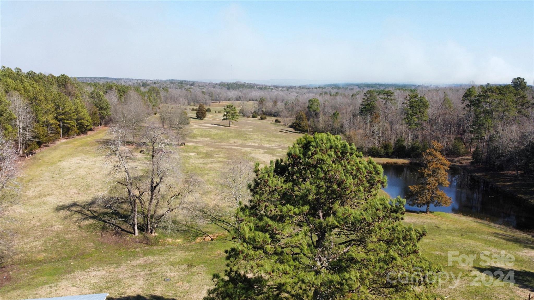 A Sportsman’s Estate nestled in the heart of nature, this sprawling 73-acre farm presents a rare opportunity to own a piece of paradise. Comprising four parcels, the estate boasts two stocked ponds set against the backdrop of gently rolling topography, offering a setting for relaxation and outdoor activities.
800 feet of frontage on Shiloh Unity Road and 520 feet on Pageland Highway, provides convenient accessibility  The property features two barns with stables, complete with perimeter and cross fencing, perfect for livestock or equestrian use.
For the hunter, a field is planted for bird and small game hunting that complements native whitetail deer and wild turkey habitat. This farm is not just a home; it’s a sportsman’s dream with ample room to roam and play in the great outdoors.
Whether you’re casting a line in the pond, tracking game through the fields, or simply enjoying the sunset from your new estate home, this estate promises a lifestyle of privacy and endless adventure.