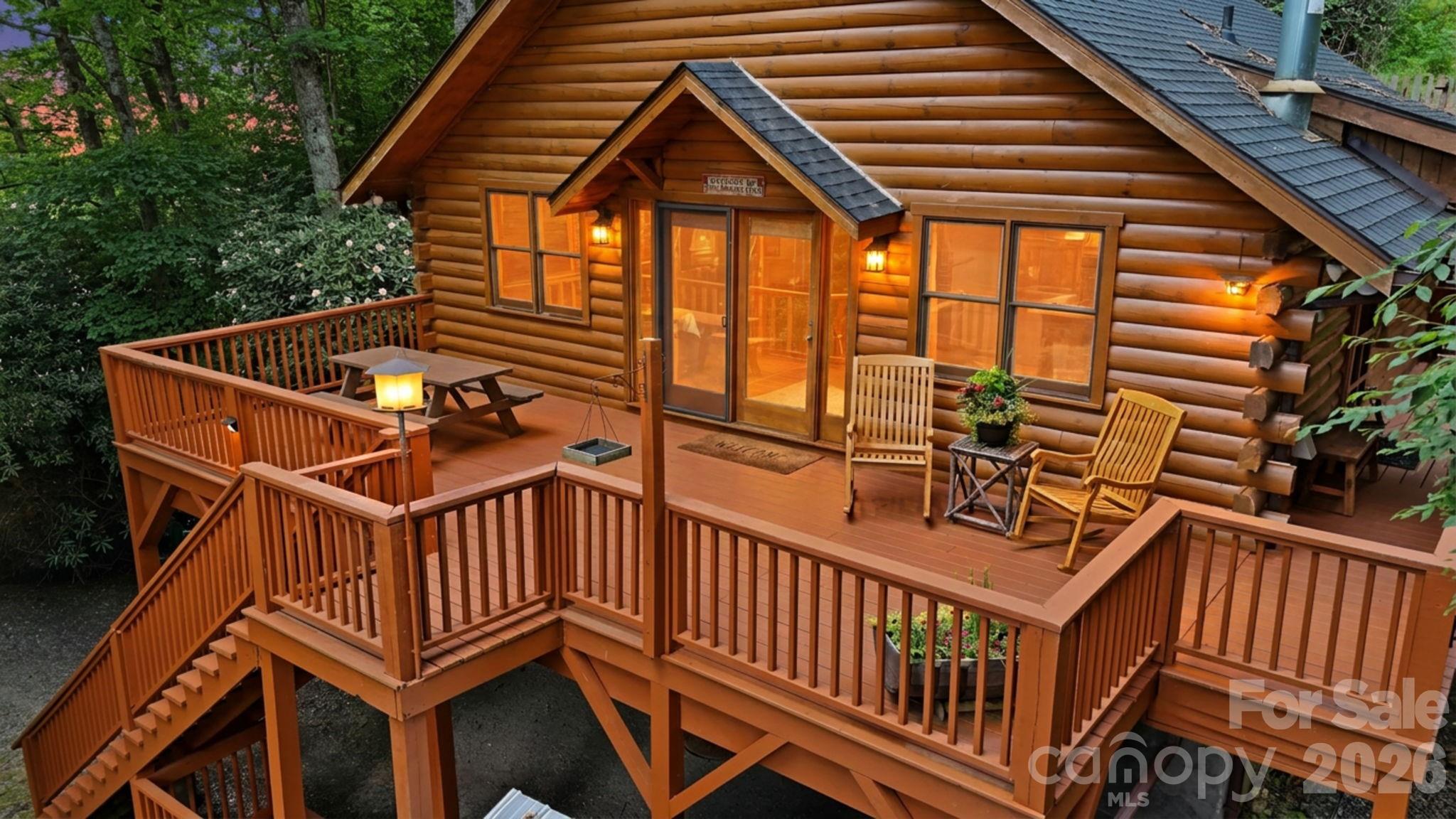 Looking for a cabin in Boone? This exceptional High Country log cabin retreat, including an ADDITIONAL LOT, offers seasonal mountain views at over 3,300 feet elevation, providing the perfect escape in the cool mountain summers and an unmatched combination of location, offering the convenience of minutes from downtown Boone while tucked into your own wooded retreat. This furnished, turn-key log cabin is a rare opportunity featuring the homesite plus an adjacent lot, offering incredible flexibility for future development, investment, resale, or buffer.

Perfectly positioned just minutes to Appalachian State University, Watauga Medical Center, Samaritan's Purse, the Blue Ridge Parkway, skiing, hiking, fly fishing, shopping, restaurants, and everything the High Country has to offer - this property combines mountain privacy with outstanding convenience.

Inside, the authentic charm of the High Country shines through, with beautiful knotty-pine walls, ceilings, and custom kitchen cabinetry throughout. The main level offers 2 bedrooms and 2 full bathrooms, highlighted by a stunning floor-to-ceiling stacked-stone fireplace, stainless steel appliances and granite counters in the kitchen, and a warm, inviting living space. The walk-out lower level expands the home's versatility with two additional bonus rooms currently used for sleeping, a third full bathroom, and a den/office space featuring a cozy and stylish free-standing gas stove.

Thoughtful upgrades and improvements include a recently replaced roof, custom walk-in tile showers on both levels, and freshly remodeled lower-level bonus rooms. 

Outdoor living is equally impressive, with over 800 square feet of deck designed to capture the mountain views and cool summer air while gathered around a cozy fire pit . Homesteaders and outdoor enthusiasts will appreciate the custom outdoor wood-fired brick oven, a fully fenced 1,000-square-foot terraced garden area, a heavy-duty storage shed, and a dedicated woodshed, all of which enhance the outdoor living spaces.

Two separate driveways provide exceptional functionality. The upper driveway includes a covered carport beneath the front deck, while the lower driveway offers ample parking and access to the additional lot. 

With premium furnishings included and the added value of an adjacent lot, this is a truly rare opportunity to own a complete mountain cabin in one of Boone's most desirable locations.
