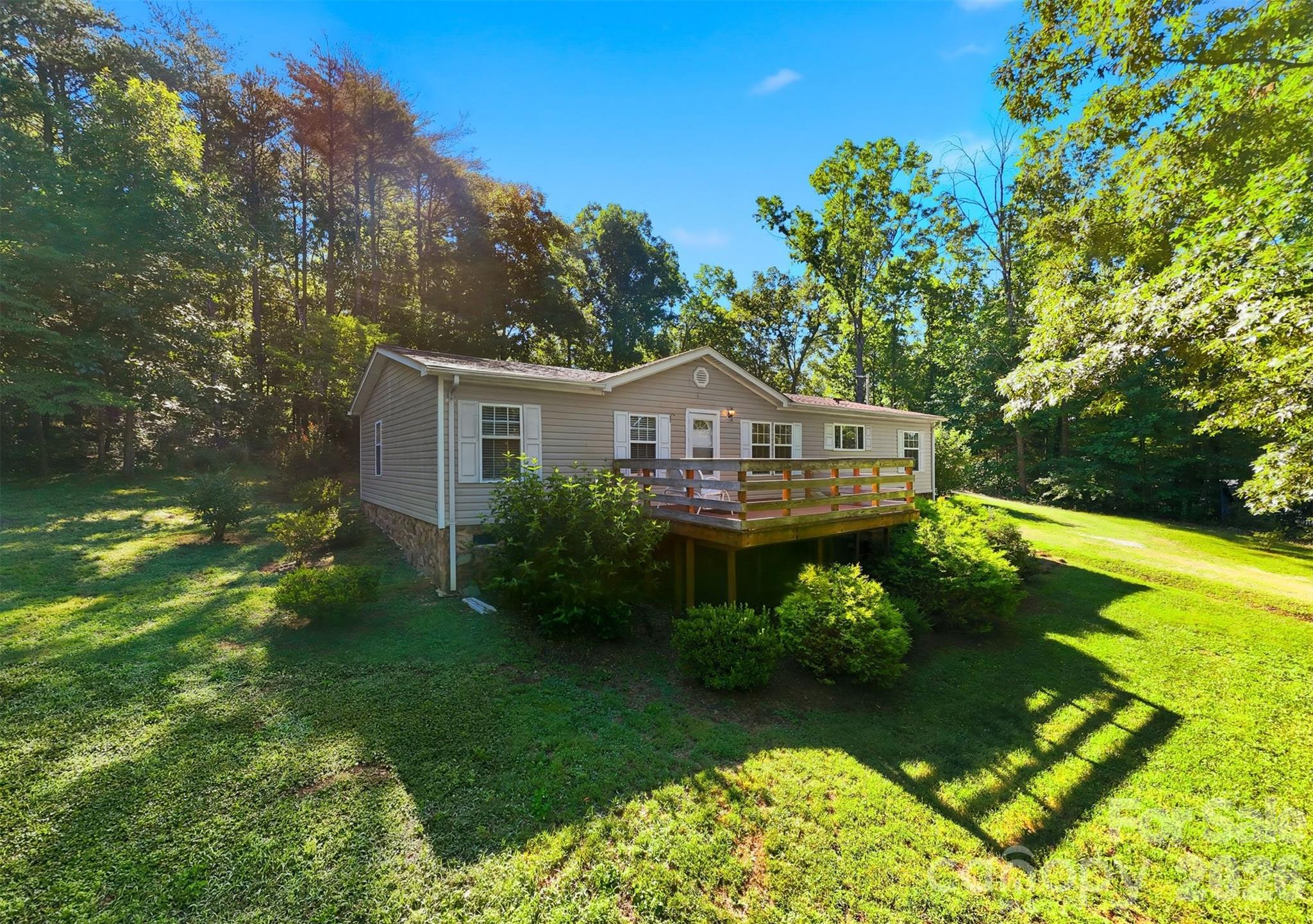 A little breathing room, mountain views on the drive in and the kind of quiet that feels hard to find. Set along a private road on 1.32 acres, this welcoming 3BR/2BA home offers space to spread out, slow down and enjoy life at a different pace, while still keeping schools, downtown Morganton, shopping, dining and I-40 within easy reach.

Everything is conveniently on one level with a great open floorplan and split bedroom layout. Warm laminate flooring runs through much of the home. A wood-burning stove adds a cozy touch when temperatures dip. The kitchen offers generous prep space and storage, and the laundry/mud room keeps everyday life practical and easy.

The primary suite is wonderfully spacious with a large soaking bath and walk-in closet, while two additional bedrooms offer flexibility for guests, hobbies or an office.

Start the day with coffee on the sprawling front porch and wind down to the sounds of the evening, then fire up the grill on the back deck for easy outdoor dinners. The 24x25 detached garage is ideal for workshop space, projects or extra storage, while two additional outbuildings provide even more flexibility for tools, hobbies or gear. Plenty of yard space leaves room for pets, gardening, play or evenings around a firepit.  Beautiful, mature landscaping puts on a show nearly all year long.

WA Young, Table Rock, Freedom schools.  Rutherford Electric, Brentwood Water.