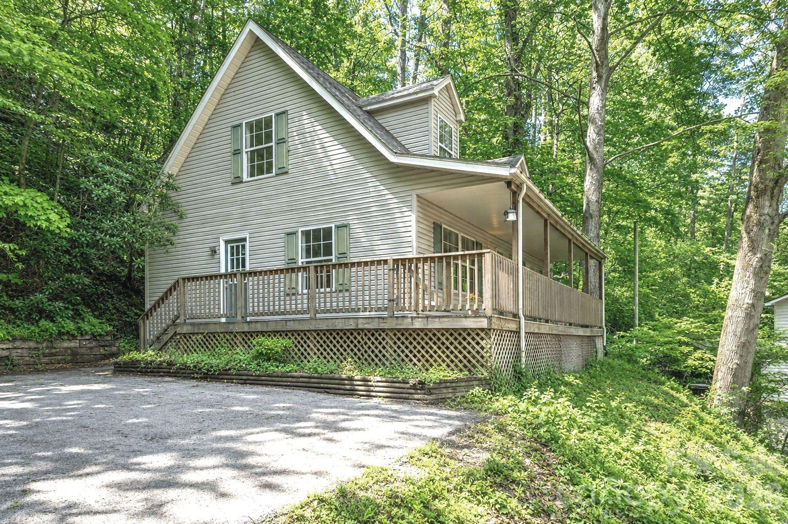 Come home to this 2BR/2.5BA + BONUS Room property in Maggie Valley Country Club Estates! This 1998-built mountain home offers comfort, convenience, and great potential! Featuring 2 bedrooms, 2.5 bathrooms, and a versatile BONUS room. Enjoy the full-length covered porch that wraps around the front and side. A large, level paved driveway provides plenty of parking for multiple vehicles. Step inside to the main level with natural light, engineered oak flooring, and a cozy gas log fireplace. The living, dining, kitchen, and laundry areas are all located on the main level for convenience, along with a half bath and the primary bedroom featuring a double-vanity ensuite bath. Upstairs, you'll find a second bedroom, a full bathroom, and a generous BONUS room with a closet. Partial fencing in the back and side yard. The carpet in the bedrooms and stairs is in poor condition. Located just 1.2 miles from the Maggie Valley Club (membership not included), enjoy access to golf, dining, fitness center, pool, and tennis with a membership. Only 7 miles to downtown Waynesville and close to many other area attractions. Short Term Rentals Allowed. Spectrum High Speed Internet. No City Taxes. $100/Yr HOA for Roads.
