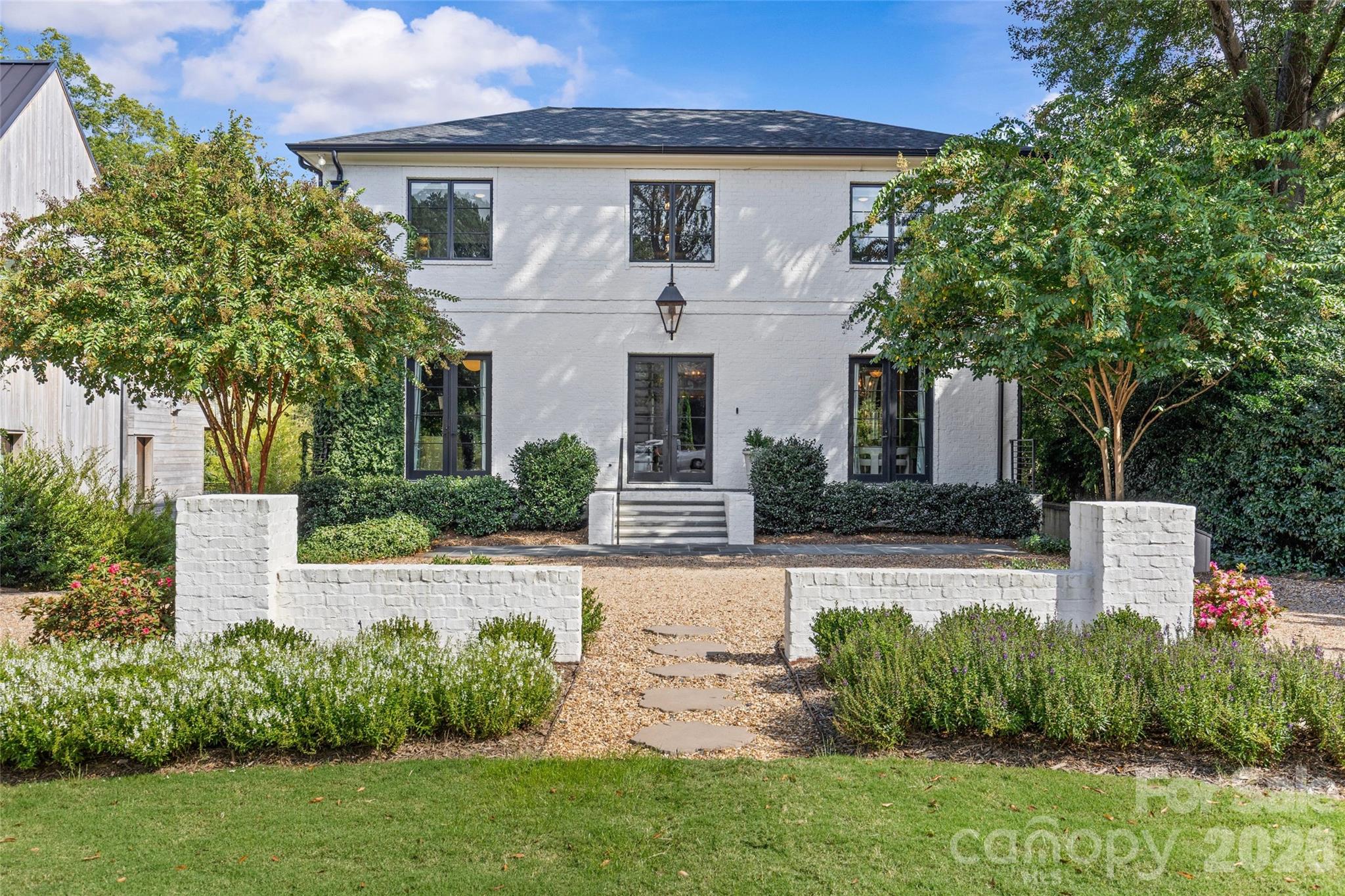Stunning custom-built residence in desirable Myers Park! Completed in 2020 by Joyce Building Co, this exceptional 5BR, 6.5BA home offers nearly 6,000 sq/ft of refined living space across 3 levels. Situated on an exceptional 1.49-acre lot just around the corner from Freedom Park and Sugar Creek Greenway, the light-filled, open floor plan boasts soaring ceilings, designer lighting, custom millwork, and gorgeous white oak hardwoods throughout. The chef’s kitchen features custom cabinetry, quartzite countertops, Thermador appliances, expansive island, walk-in pantry and bar! The adjacent breakfast area and family room, with exposed beams and cast stone fireplace, flow seamlessly to a covered terrace with fireplace, heaters, and views of the lush backyard & pool. Upstairs find the luxurious primary suite with dual walk-in closets and spa-like bath, along with four spacious secondary bedrooms, all with custom closets and en-suite baths. The lower level offers a media room, exercise room with sauna and full bath, and a den opening to a covered patio with built-in grilling station, which extends to the saltwater pool/hot tub! With a 3-car garage, circular drive, and beautifully landscaped grounds, this home blends timeless design, modern amenities, and exceptional outdoor living in one of Charlotte’s most sought-after neighborhoods.