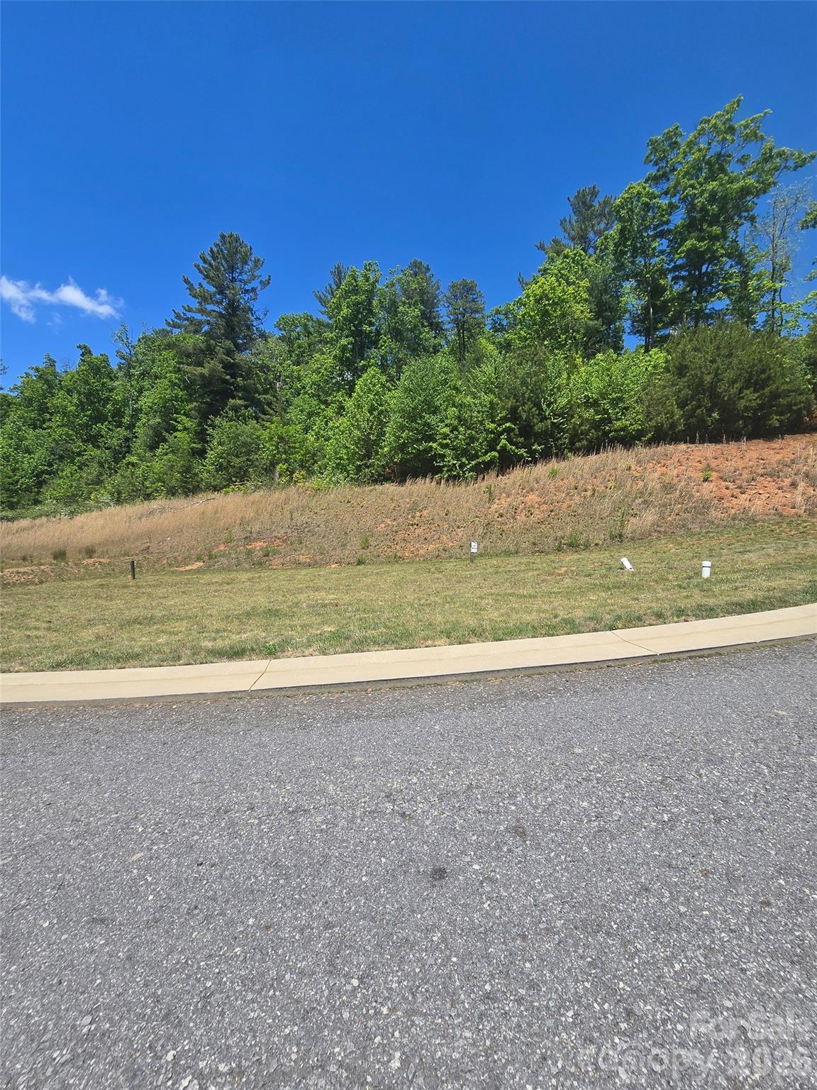 Priced to sell, below tax value! Build your mountain getaway or income-producing retreat on this ready-to-build 0.33-acre homesite in the Westside Village community of Fairview, minutes from Asheville. Short-term rentals are allowed, making this an excellent opportunity for investors or buyers seeking a flexible primary, second home, or vacation property. This homesite offers the convenience of city water and city sewer. Even better, lawn maintenance is included in the HOA dues, making ownership low-maintenance and ideal for part-time residents or rental use. Enjoy the charm of mountain living within easy reach of shopping, dining, outdoor recreation, and vibrant downtown.