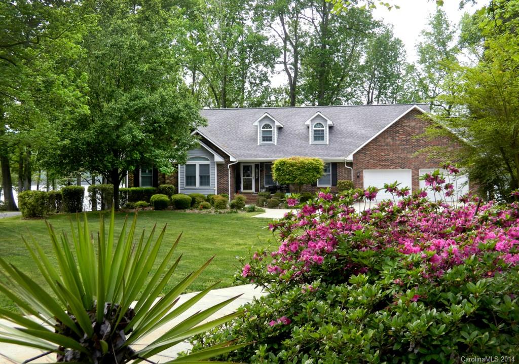 Beautiful LAKE TILLERY custom home, stunning landscape, treasured flat lot, spectacular view of Morrow Mountain.  Casual elegance, Open living at it's best, lake views from every room. Custom kitchen, breakfast bar, stainless, solid surface. Master French doors to private deck, huge bath & closets.Lower level could be 2nd quarters with master suite.  Bonus currently craft room could be bedroom. Large boathouse with screened porch and A/C storage. 250'+ waterfront. Most window treatments convey.