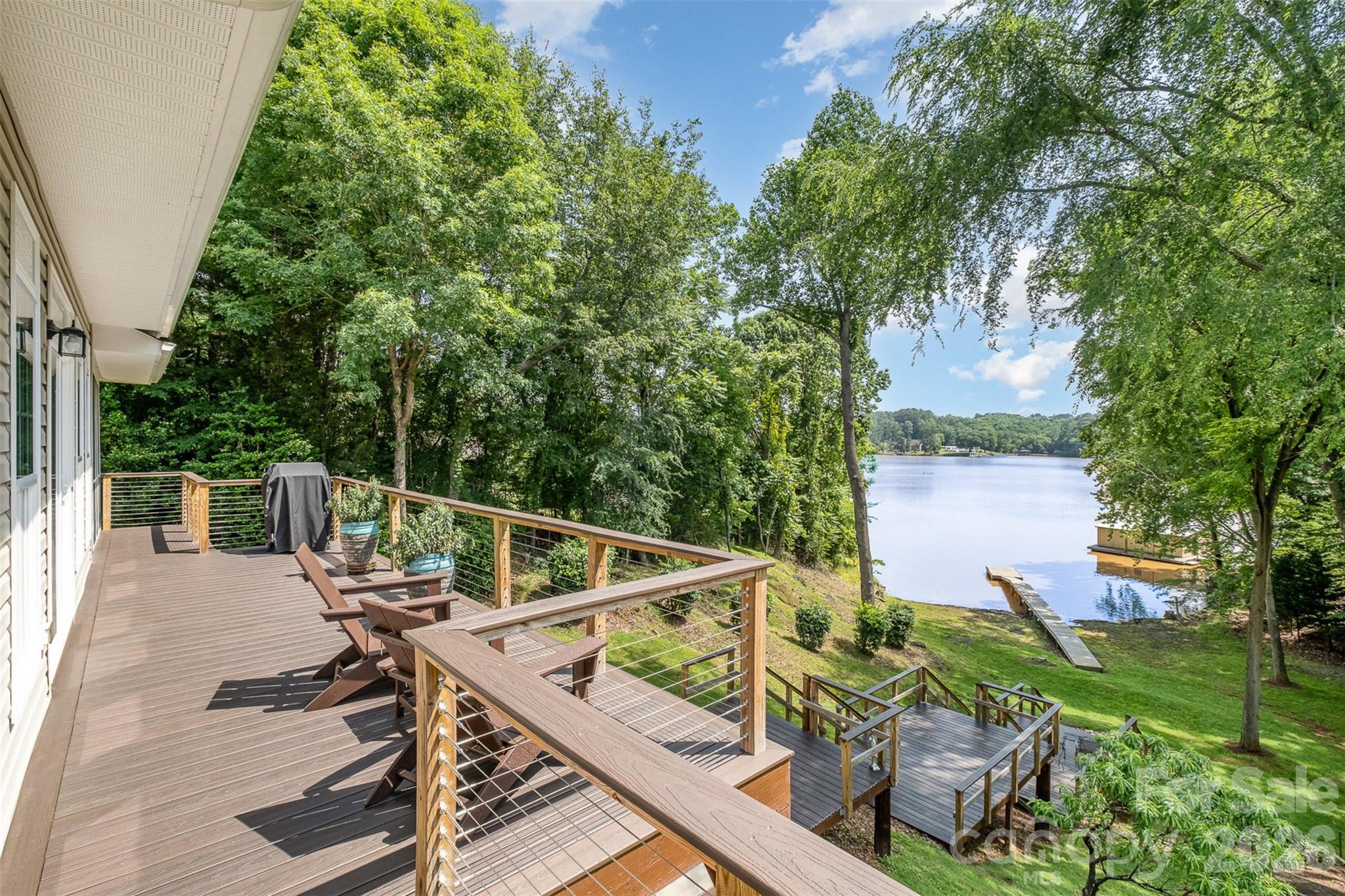 Private waterfront retreat on a rare 1.49-acre lakefront parcel offering stunning year-round lake views, beautiful landscaping, new decking, interior improvements, and a renovated carriage house. The main home features open-concept living with a spacious primary suite on the main level, updated bathrooms, a screened porch, and a modern gourmet kitchen with quartz countertops, upgraded appliances, and a separate bar area. The beautifully finished walkout basement offers flexibility with a full bath and ideal space for a secondary living area, guest retreat, home office, den, or fitness room. Glass doors lead directly to a covered porch and new stairs showcasing waterfront views. A gated entrance across the property leads to additional parking and the renovated carriage house featuring upper-level living quarters with a full bath, perfect for guests, multigenerational living, a home office, studio, or potential short-term rental opportunity. Below is an expansive 800+ sq ft workshop/garage with a half bath, offering endless possibilities for hobbies, storage, boats, tractors, or recreational equipment. Covered sheds, mature landscaping, blueberry bushes, and abundant wildlife create a true nature-lover’s paradise while still offering an easy commute to Charlotte, the airport, and charming downtown Belmont.