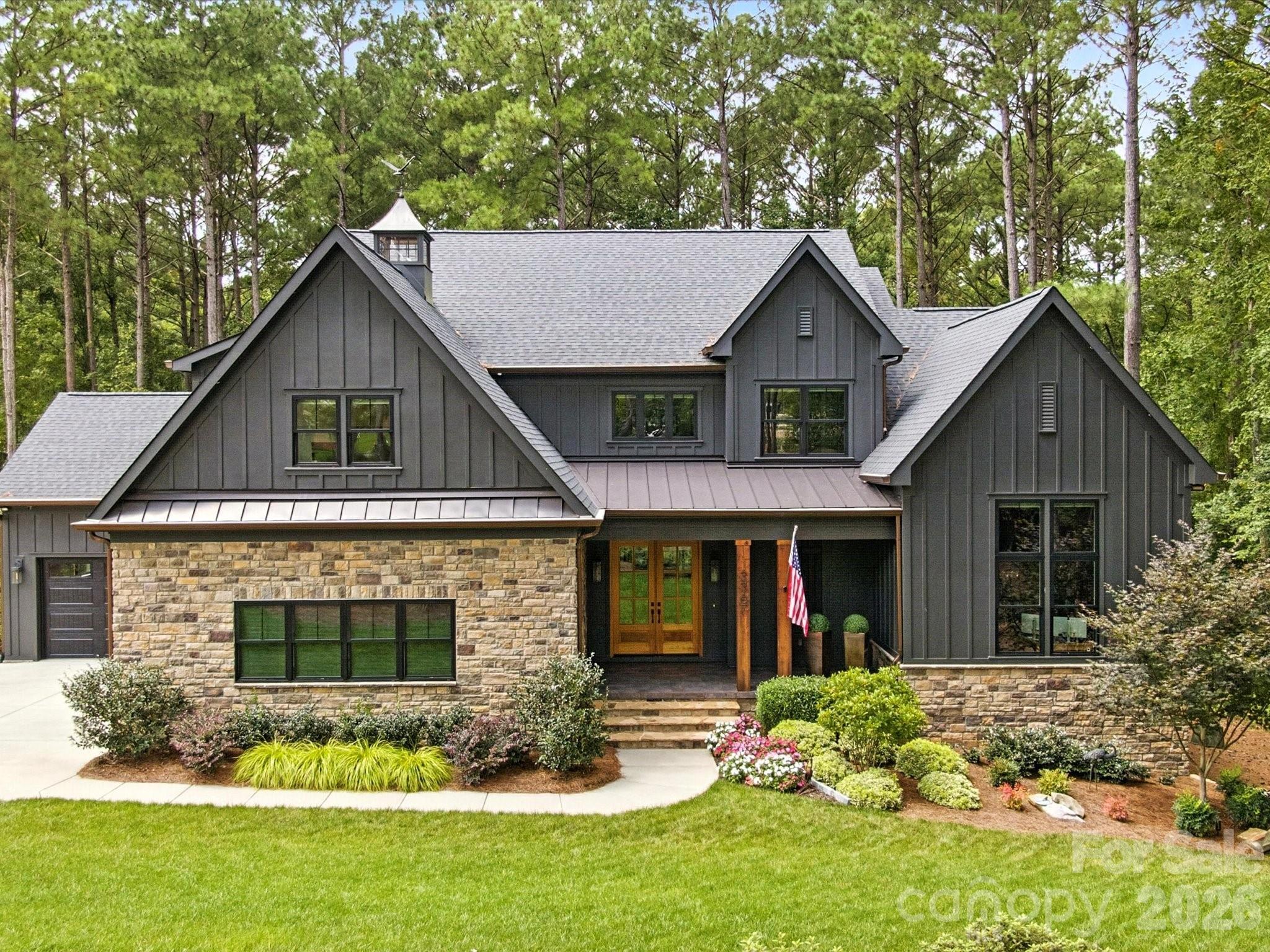 Custom luxury meets modern living in this exceptional estate set on a private, wooded lot close to an acre! This home offers over 4,300 sq ft of finished living space plus a huge walkout daylight basement you can design and customize to fit your needs. The open floor plan features white oak hardwood floors throughout, tons of natural light and the perfect flow for entertaining. The gourmet kitchen enhanced with quartz counters, Monogram appliances including two dishwashers, gas cooktop, pot filler and beverage fridge. The great room includes a coffered ceiling, linear gas fireplace, and stacking sliding doors that open to a huge screened porch that feels cozy and overlooks spectacular wooded views. The main-level primary suite offers a spa-style bath with heated floors, oversized walk-in shower, and a custom walk-through closet with laundry access. Two dedicated home offices are also located on the main level. Upstairs includes an ensuite bedroom, additional bedrooms with shared bath access, and a spacious bonus room. The walkout basement provides excellent potential for future living space with a separate entrance, plumbing in place, and a large workshop or studio area. It also features a hidden vault room to store valuables and serve as a panic room. Additional highlights include a fully automated smart home system that controls all shades, lights and security, oversized garages, a whole house generator and access to community amenities including pool, clubhouse, pickleball courts, trails, and river access. Convenient location with low county taxes and easy access to shopping, dining, and Charlotte.