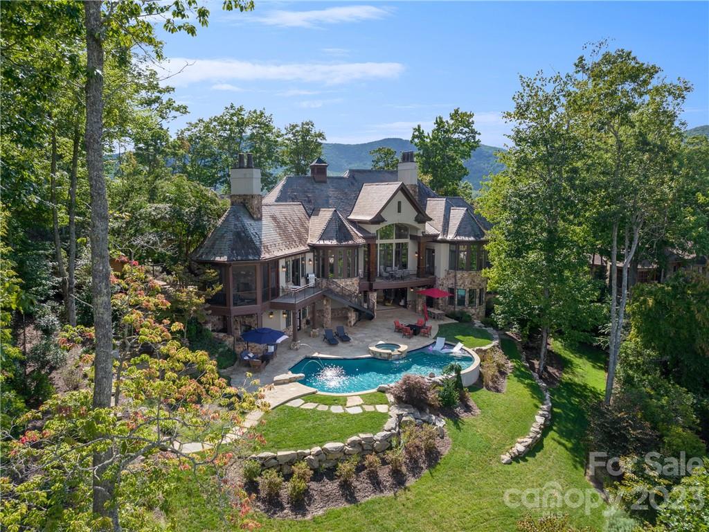 Luxurious custom-built estate in The Cliffs at Walnut Cove providing year-round mountain views. This thoughtfully designed home offers an abundance of natural light and exquisite custom ceilings. Exceptionally planned grand main living space overlooks the resort-style pool with waterfall. Flowing naturally from room to room and offering an open concept gourmet kitchen, gorgeous dining nook and floor-to-ceiling windows with sweeping views of the Blue Ridge Mountains. Enjoy expansive decks and a year-round porch with a custom stone fireplace. Well-appointed primary suite with a private balcony. A graceful, curved staircase leads to the terrace living area with limitless venues for entertaining. Glass pocket doors provide seamless integration of indoor/outdoor living. Guests easily navigate from the inviting bar to the stunning pool. Highlights include outdoor sauna, wine cellar, media room, multiple mixed-use rooms, seven fireplaces, elevator, and immaculate three-car garage.