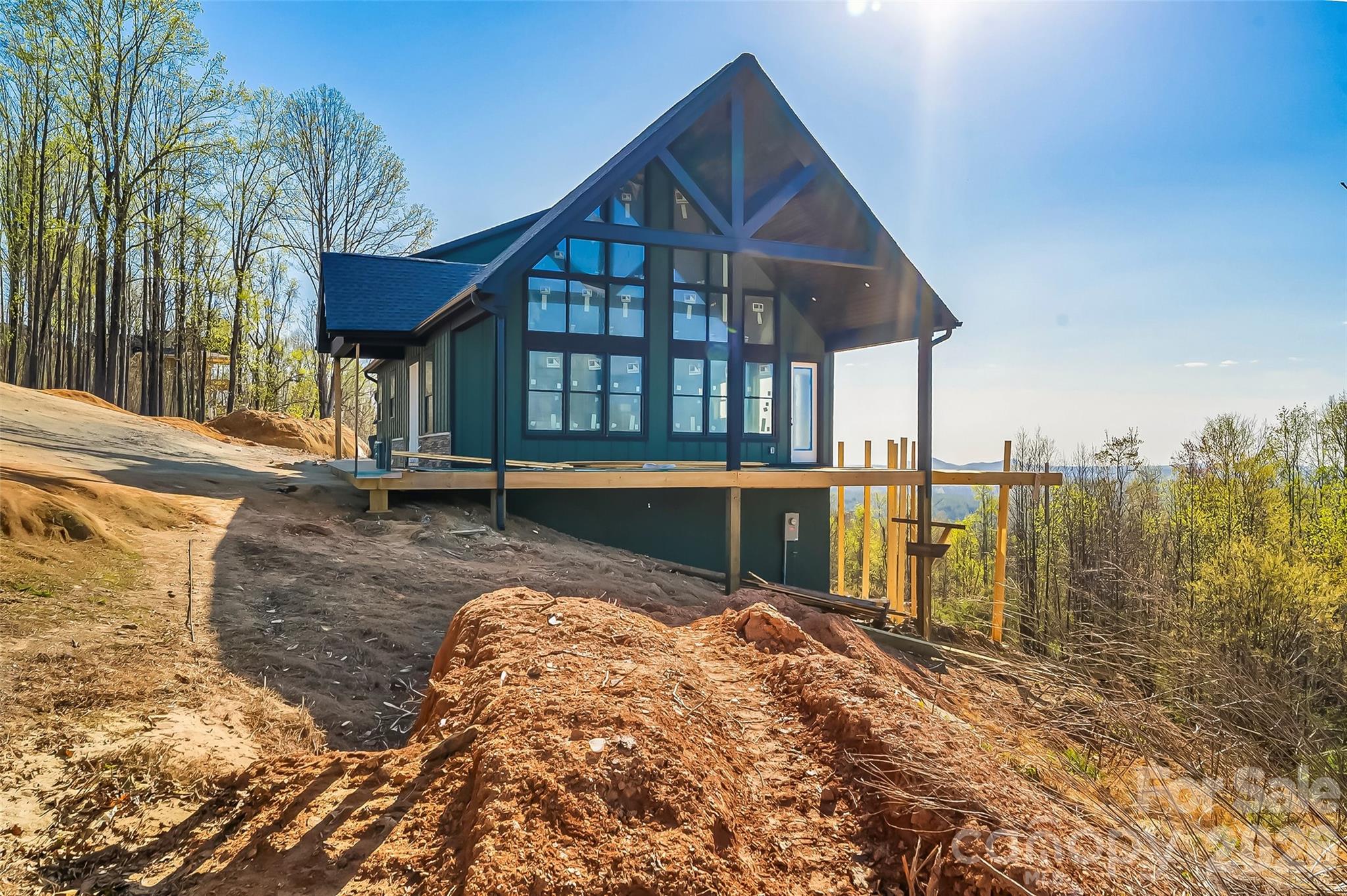 WOW!!! If you think the views are amazing from these pictures, just wait until you see it in person. This custom built home sits on the mountain top with long range, 360 degree views of Grandfather Mountain, Table Rock, and Hawks Bill from the front and South Mountain from the back. It's truly breathtaking. Three floors of luxury design include 3 bedrooms, 4.5 bathrooms, 3 flex spaces with doors and closets, and a full second living quarters in the walkout basement. The soaring ceilings, massive windows, and expansive wrap around porch highlight the most extraordinary views. Every detail has been carefully considered, and the home, beautifully crafted. Nestled in the heart of the Blue Ridge, The Coves Mountain River Club is more than just a mountain community—it’s a gated, idyllic retreat where the scenery does the talking. With five miles of pristine Johns River frontage leading into the breathtaking Wilson Creek Gorge, this is a place where life naturally finds its rhythm. While soaking in the panoramic peaks, you'll find that "the good life" isn't just a phrase here; it’s the standard. The incredible community ammenities include a stunning mountain top lodge, an inground pool, pickleball courts, several commnity barns and gardens, walking trails, and so much more. The home is still under construction with an expected finish date of mid-June. More pictures of the completed spaces will be added soon.