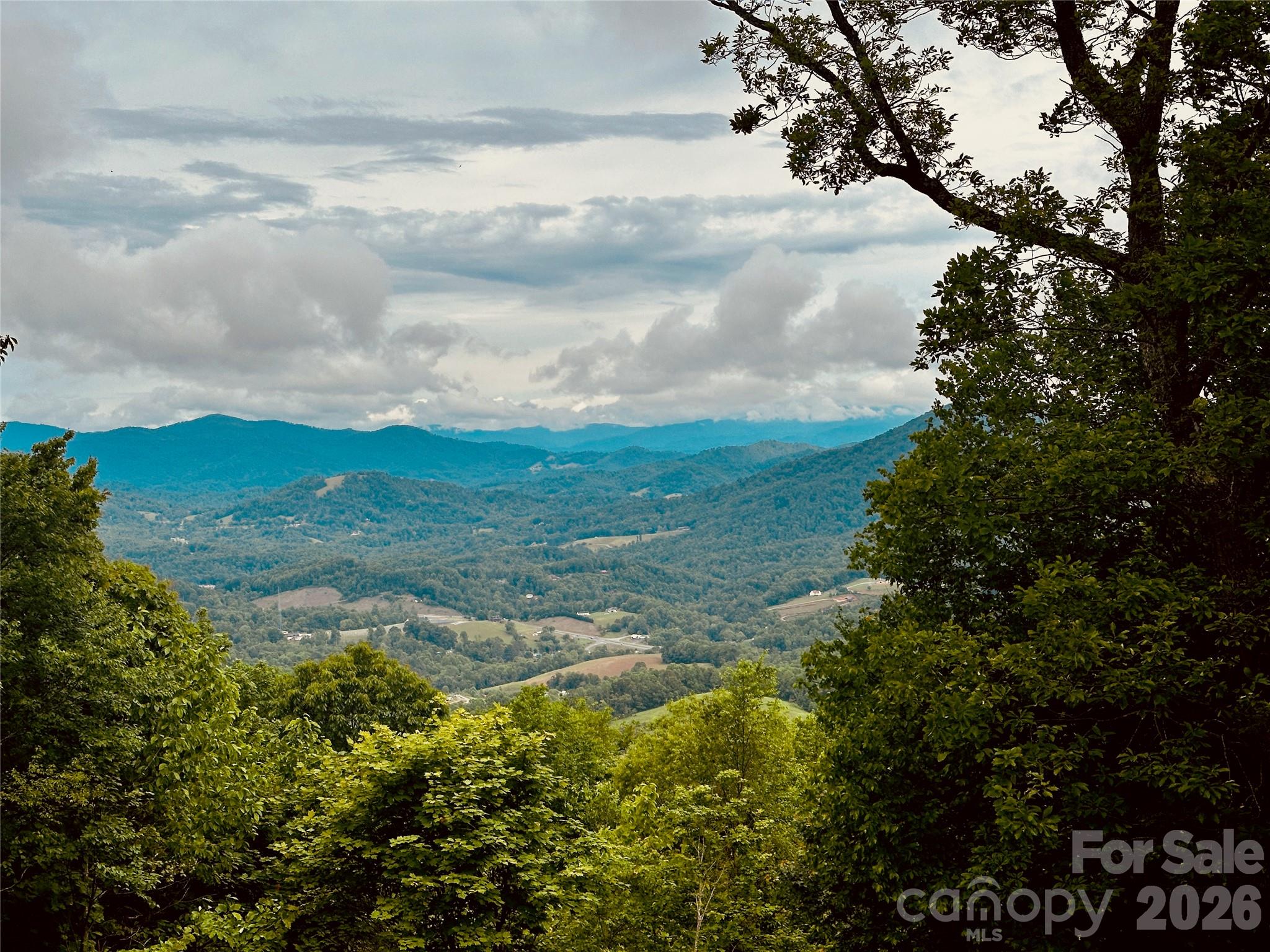Escape to Arrowhead Retreat, a breathtaking 4-bedroom, 2-bath mountaintop pavilion-style home on 2.57 high-altitude acres, offering unrivaled panoramic views of misty Blue Ridge Mountains and lush valleys. Nestled just off US Hwy. 19-E between Burnsville and Spruce Pine, NC, this rare gem combines serene privacy with convenient access to the Penland School of Crafts, and vibrant local communities—10 minutes to Spruce Pine, 15 to Burnsville, 50 to Asheville, and 2 hours from Charlotte.
UNPARALLELED VIEWS & EXCLUSIVITY: Revel in an 89-mile view-shed, where sunlight and cloud shadows dance across ancient peaks, rivaling the finest Blue Ridge Parkway overlooks. Known as “Elo Gadusi Tsudisdaya” (The Land of Unending Mountains) by the Cherokees, this property offers a front-row seat to nature’s grandeur. With zoning-free land and light deed protections, additional adjoining lots are available to expand your legacy or own the entire mountaintop.
ARCHITECTURAL MASTERY & SUSTAINABILITY: Built in 2011 by master craftsman J.R. Simmons, this Deltec®-designed home is engineered for strength and efficiency, using Southern Georgia Yellow Pine and BluWood® framing to resist rot, mold, and termites. Featuring Marvin® double-pane impact windows, James Hardie® siding, and a hurricane-rated roof, it’s built to withstand extreme weather. A 5.7KW solar system by Sundance Power Systems, a Generac® 18KW propane generator, and a 1,500-gallon rainwater collection system with advanced purification ensure sustainable living. Superior Walls® precast concrete foundations and Fiberon® composite decking enhance durability and eco-friendliness.
INTERIOR ELEGANCE: Step into an open floor plan with vaulted pickled-pine ceilings, reclaimed antique pine floors, and oversized windows framing ever-changing vistas. The craftsman-style kitchen boasts GE Profile™ appliances, quartz countertops, a curved island, and custom maple cabinetry by local artisan John Pendley. A Bari® soapstone rotating fireplace, meeting 2020 EPA standards, adds warmth and sophistication. The helical staircase, with rope-inlaid handrails and ornate ironwork, leads to a light-filled upper landing. The master suite features dual vanities, a jetted tub, and a walk-in closet, while the lower level offers an entertainment area with a kegerator bar, Bark House® accents, and a Jotul® wood stove.
LIFESTYLE & AMENITIES: Enjoy radiant floor heating, ductless hybrid heat/AC, and a whole-house dehumidifier. The lower-level media room, guest bath with a stand-up urinal, and walk-out gravel area elevate entertainment. A scullery/pantry, laundry room, and supersized garage with workshop potential add functionality. Native wildlife and a diverse ecosystem thrive in this National Park-like setting, perfect for families or retreats.
YOUR MOUNTAIN LEGACY AWAITS: At 1024 Arrowhead Ridge Road, every drive is scenic, every sunset unforgettable. Leave stress behind and embrace a lifestyle where altitude uplifts your attitude. This is mountain living at its finest—secure, sustainable, and exclusive. Schedule your private tour today to claim your piece of the Eternal Mountains!