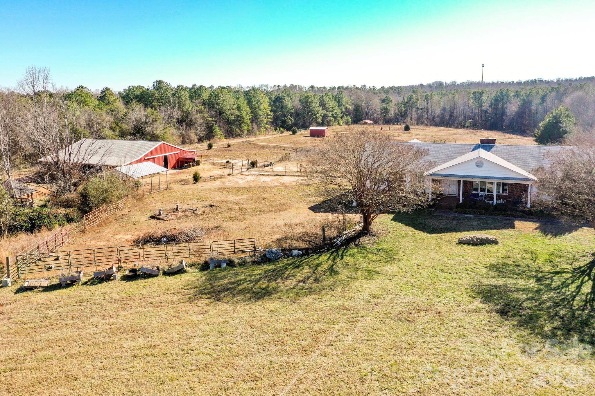 Rare equestrian opportunity on 23.75 acres just 15 minutes from Tryon International Equestrian Center. This versatile property features a spacious home, well-designed barn, fenced pastures, creek frontage, and exceptional potential for future expansion or investment.

The 4,000+ sq ft brick ranch offers 4 bedrooms and 3.5 baths with a finished basement. Interior features include a sunroom, home office or craft room, and ample living space ready for customization. Additional improvements include a two-car garage and a detached 24’ x 32’ workshop ideal for equipment, hobbies, or storage.

Equestrian facilities include a 44’ x 60’ metal barn with 12-foot shed roofs on both sides and a 16-foot concrete center aisle/parlor. The barn is equipped with eight 12’ x 12’ stalls, tack room, half bath, medications room, and wash area—well suited for private use or boarding operations.

The farm is serviced by public water and consists of gently rolling, mostly level pastureland with a small creek. Approximately 850 feet of road frontage provides multiple potential building sites along the road and throughout the acreage, offering flexibility for future homes, expansion, or subdivision potential.

While the home and farm will benefit from updates, this property presents an outstanding canvas for renovation and long-term value—ideal for an equestrian estate, family compound, or multi-homesite investment.

NEW ROOF JUST INSTALLED - 3/1/2026 - LOOK AT THE NEW BACK DECK ADDED AT NO ADDITIONAL RISE TO SELING PRICE.