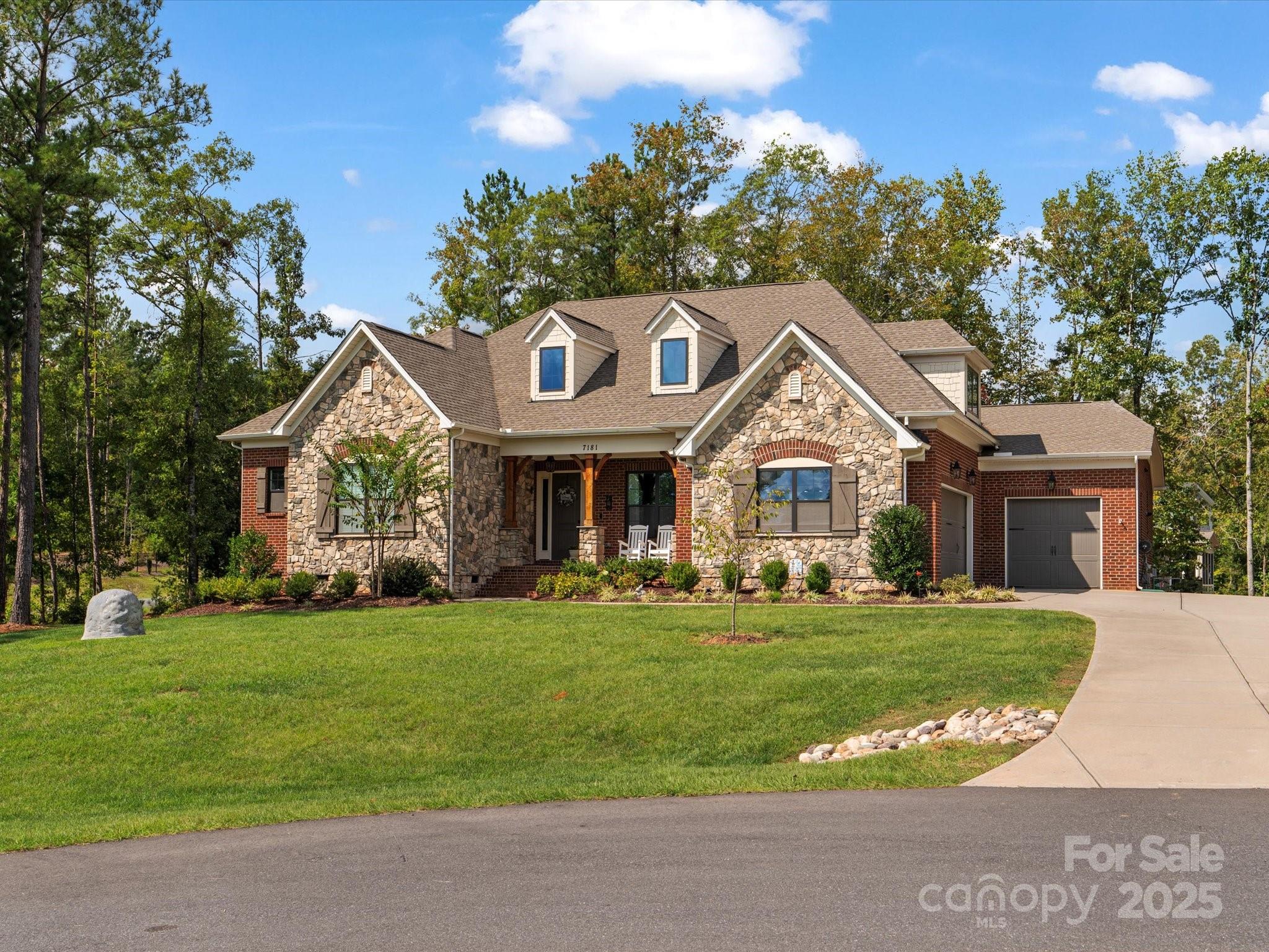 This stunning brick and stone home is perfectly situated on a corner lot in a peaceful cul-de-sac in highly desirable Trinity Ridge neighborhood! Featuring hardwood floors throughout the main living areas, it boasts a bright, open layout with coffered ceilings in the dining room and a cozy stone gas fireplace in the great room. The white kitchen is a chef’s dream, offering quartz countertops, a gas stove, stainless steel appliances, a large island all overlooking a spacious breakfast nook. The main floor includes a primary suite with a tray ceiling, dual vanities, and an oversized shower, plus two bedrooms sharing a Jack-and-Jill bath, and a third BR that could also make a great office or playroom. Upstairs, enjoy a 4th BR/bonus room. Step outside to a screened porch, extensive hardscaped patio with built-in seating, stone gas firepit & gas line for grill ... all surrounded by a wooded backyard for ultimate relaxation. A 3-car garage and flat driveway complete this incredible home!