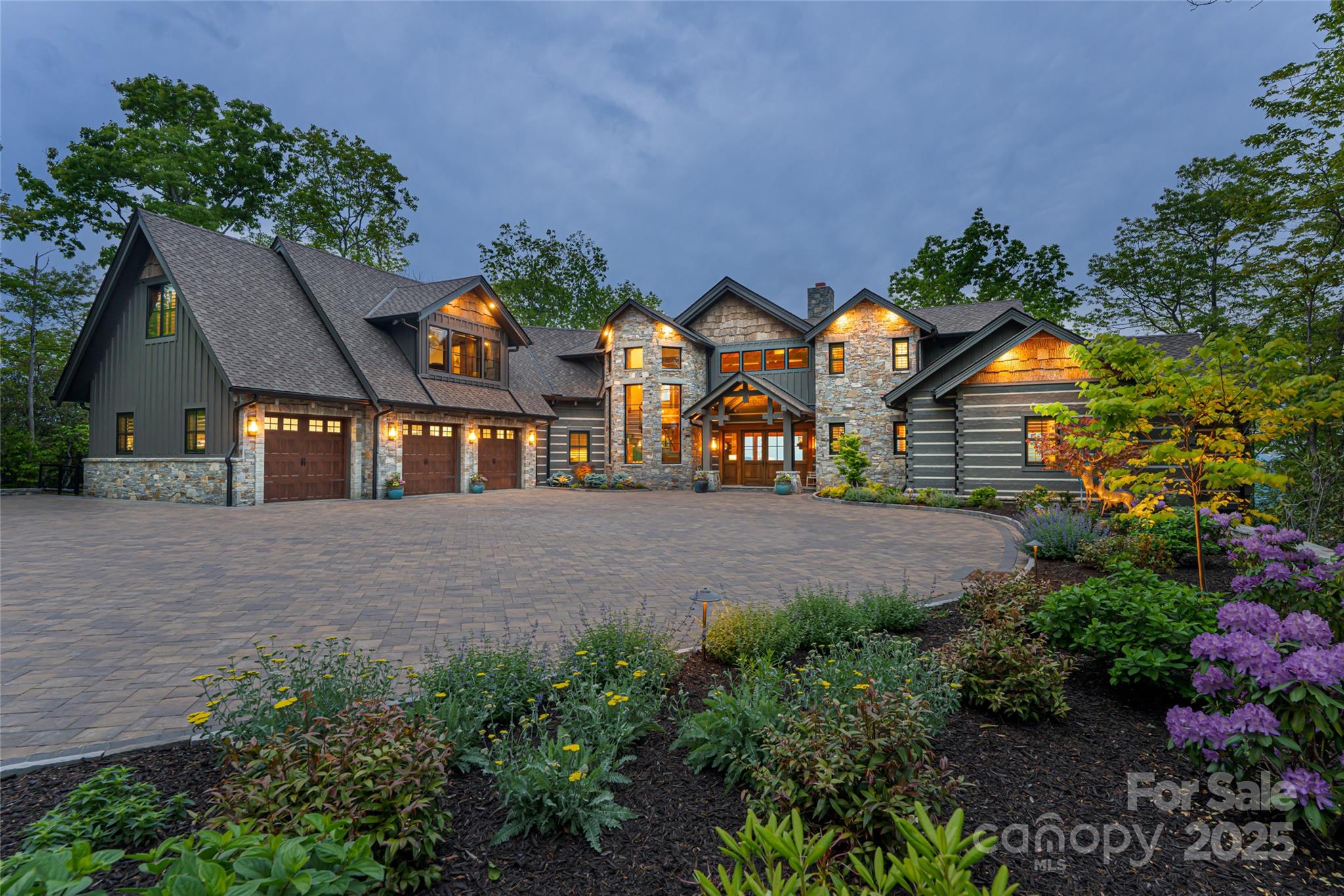 Enter a living masterpiece at 511 Asgi Trail, a rare blend of architectural brilliance, natural grandeur and bespoke luxury within one of Maggie Valley’s desirable enclaves. Crafted by the area's premier builder, this 2023 log-and-stone chalet is a sensory experience, framed by panoramic views, curated with three levels of world-class lifestyle amenities and infused with intention at every turn. Indulge in a chef’s kitchen with Sub-Zero/Wolf appliances, a spa-inspired wellness sanctuary with sauna and massage suite, state-of-the-art gym, cocktail lounge, cinematic theatre, and wine cellar that’s functional and architecturally impactful. Over 3,000 square feet of decking, complete with three fire pits, summer kitchen with fireplace and a recessed hot tub, invites year-round connection to nature. Electric blinds, heated bath floors and whole-home audio system elevate the everyday. Gated and minutes to area attractions, this home elevates the exceptional, bold, refined and unforgettable.