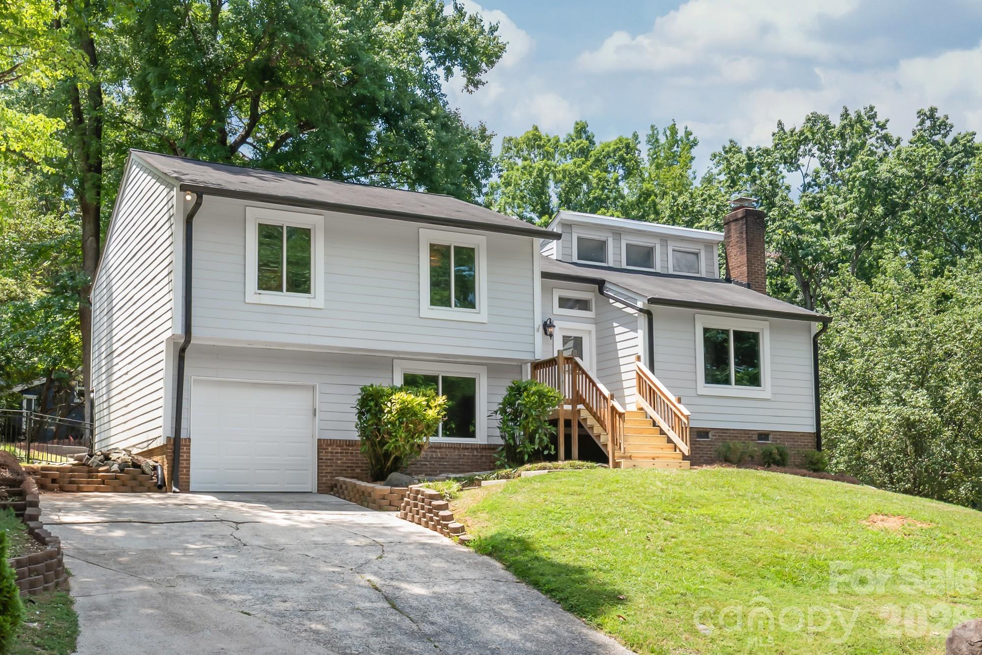 Nestled on a corner lot in one of South Charlotte's most adored country club communities, this well maintained split level home offers timeless character, thoughtful updates, and an exceptional setting. Step inside to a bright, airy main living space where soaring vaulted ceilings and clerestory windows flood the family room, dining area, and kitchen with natural light, creating an open and inviting atmosphere that's perfect for everyday living and entertaining alike.  Recent interior painting and exterior maintenance make this home move in ready.  Upstairs, the spacious owner's suite features a generous closet and private bath, where two additional bedrooms share a full hall bath. The lower level offers a comfortable den as a flexible living space, plus a deep garage with room for storage or a workshop. Outside, the gently sloping corner lot opens to a surprisingly usable backyard, complete with aluminum fencing and a covered, screened deck for enjoying the outdoors year round. Optional membership to Raintree Country Club offers access to two championship golf courses, tennis, swimming, dining, and more.  Ownership of this home includes a waiver of the club's initiation fee, providing a valuable opportunity for those wishing to join.