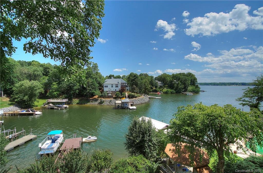 Tega Cay waterfront home with apartment for extended family or pampered guests! Main channel sunset views for miles from this 3-level home. Main level has kitchen w/ hearth room, formal living & dining, plus master and 2nd bedroom. Lower level designed for entertaining w/ 2nd kitchen, billiards, rec room, 2 bdrms, plus spacious cvrd porch for outdoor living. Apartment level has 2 bedrooms, kitchen, living room and private deck! Even more space (unfinished) above 3-car garage. Dock & boat lift.