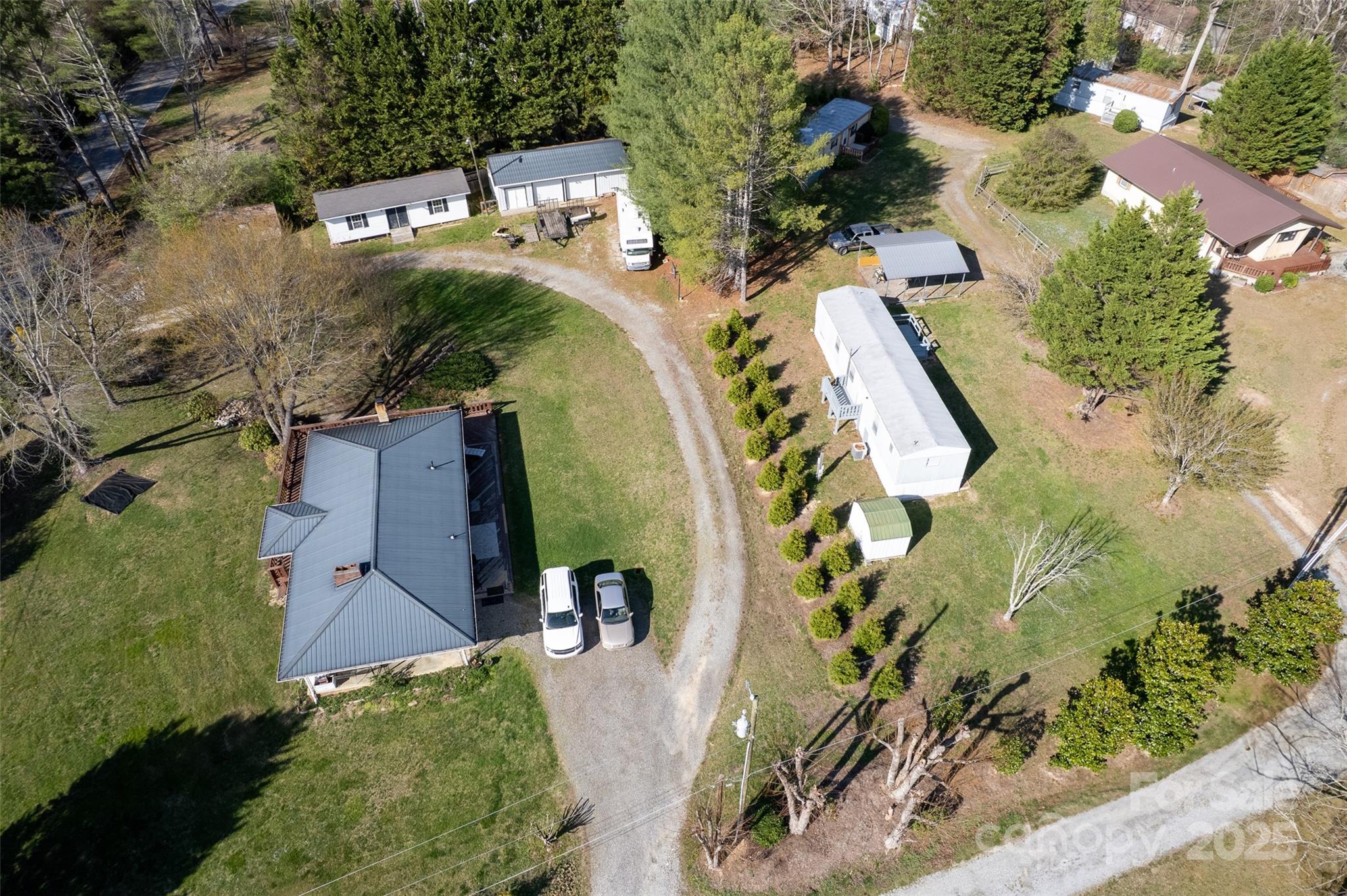 This property has the potential for 5 home rentals and 10 mobile lot rentals.  Two workshops are an added bonus, as well as,  convenience to Hendersonville all within a country setting. The property has easy road, interstate, and city water access. Four mobile homes and two workshops convey with the purchase of the brick ranch home. Doties Lane has four mobile home lots currently rented and six other lots available. One workshop has two bays with an eight inch concrete floor and the other workshop has an installed mini split unit system and septic system. Take advantage of the multiple investments and income the seller has implemented.  Downstairs bedroom and bath in main home are not counted in square footage even though it is heated due to lack of continuous access.