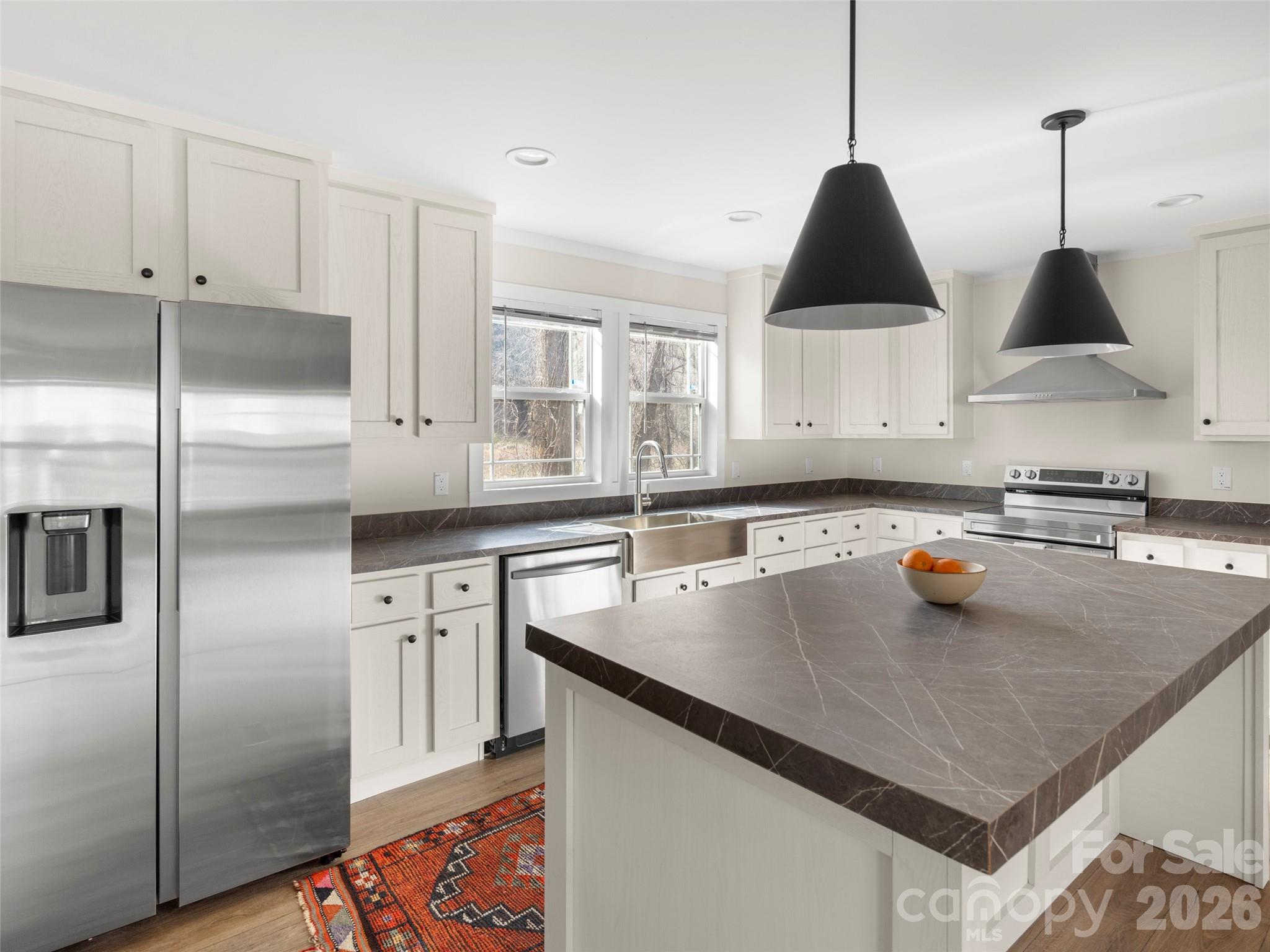 Tucked in Fairview, this brand-new home strikes that sweet spot between peaceful mountain living and everyday convenience. Set on a 0.45-acre lot with city water and sewer, it offers easy, one-level living just 12 miles from Asheville. The kitchen, dining, and living areas flow together, creating a welcoming space that feels both functional and inviting. The kitchen stands out for its large center island with seating, stainless steel hood vent, farmhouse sink, pantry, and built-in charging station with shelving to keep everyday items organized. The split-bedroom design provides added privacy, with the primary suite set apart from the secondary bedrooms. The primary bath has a tiled shower, freestanding soaking tub, and ample linen storage. A spacious utility/mud room adds even more storage and includes direct access to the back deck. With no restrictions or HOA, this property offers the flexibility to serve as a primary residence, vacation home, or investment opportunity. Don't miss out on this one!
