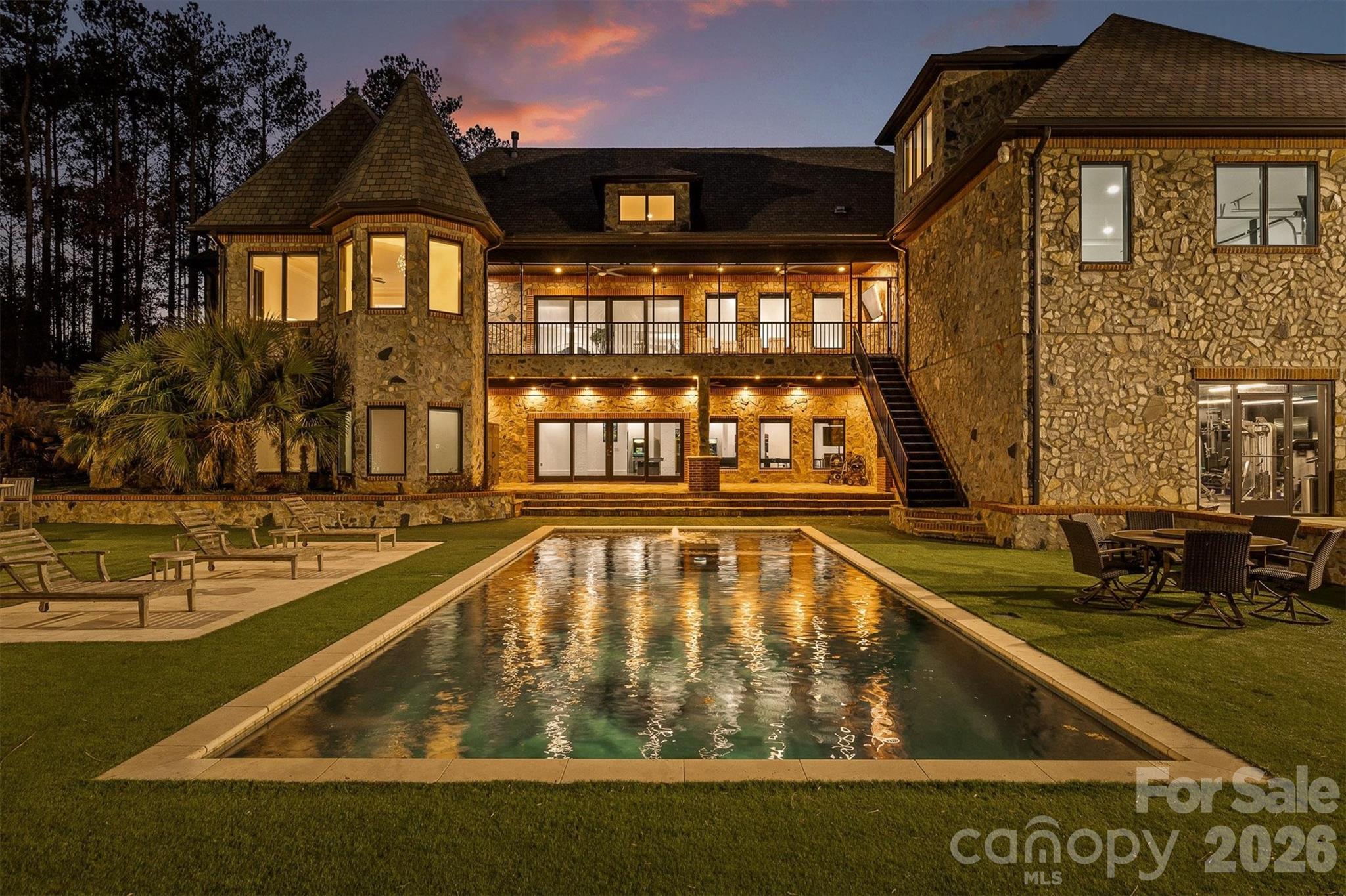 Welcome to the Crown Jewel of Lake Norman Living. Resort Living
Tucked away in the prestigious Twinn Coves on Morrison community, this magnificent gated Modern Tuscan Estate sits on nearly 9 private acres just minutes from the sparkling shores of Lake Norman State Park. Custom-built with obsessive attention to detail, this 11,241 square foot masterpiece blends Old World elegance with modern luxury — and elevates the very definition of resort-style living.
From the moment you arrive through the private gated entrance, it's clear this is no ordinary estate. Soaring ceilings, select marble tiling, and curated finishes set the tone throughout, while expansive entertaining spaces on every level ensure there's always room for the grandest of gatherings. The chef's kitchen is as functional as it is stunning, and the custom-designed wine cellar — crafted in a rich, old-world style — is a connoisseur's dream.
Entertainment here isn't an afterthought — it's a lifestyle. Host cinematic nights in your private in-home movie theatre, challenge guests in the vintage arcade game room, get a fresh cut in your very own in-home barbershop, or wind down in the sophisticated wine room. For fitness enthusiasts, a fully equipped indoor gym keeps you at your best without ever leaving home.
Step outside and enter your personal resort. A sparkling pool and expansive pool house with outdoor cooking area anchor the grounds, while a half football field, outdoor basketball court, custom mini golf course, and a playground set ensure fun for every age and every occasion. The lush, meticulously maintained acreage also features walking trails and room to roam — a rare combination of space and serenity.
Security and peace of mind come standard, with a comprehensive whole-home security system featuring full-range camera coverage and a gated private entry keeping the estate fully protected.
All of this, just moments from the waterfront dining, boating, and vibrant recreation of Lake Norman — and with easy access to I-77 for a seamless commute to Charlotte.
This is more than a home. It's a destination. Schedule your private showing today.