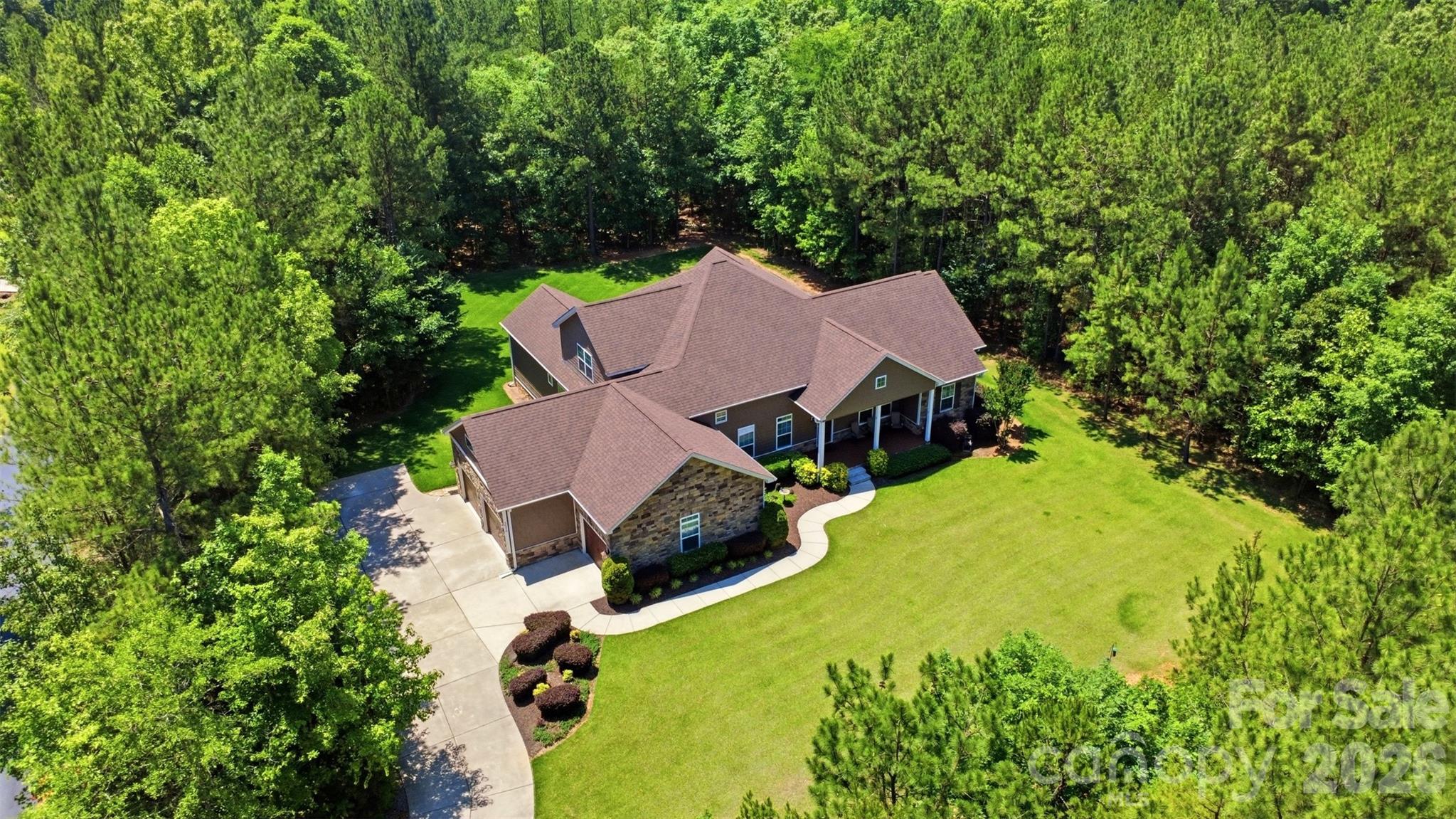 Expertly crafted by Dennis Gaston, this custom-built 4 bedroom/3 full/2 half bath residence is gracefully set on 2 private, wooded acres, offering you a rare blend of refined living and serene natural surroundings. Thoughtful landscaping and expansive wooded buffers create a peaceful, retreat-like setting with exceptional privacy!

A covered Trex front porch welcomes you inside, where engineered hardwood floors span a light-filled, open-concept main level designed for both everyday living and elevated entertaining. The formal dining room flows seamlessly into a well-appointed chef’s kitchen, complete with granite countertops, soft-close cabinetry, stainless steel appliances and abundant cabinet and countertop storage. The adjoining breakfast area and inviting living room, anchored by a cozy fireplace, open effortlessly into a fully insulated sunroom, capturing tranquil views of the backyard year-round.

The main-level primary suite is a true sanctuary, featuring tray ceilings and a spa-inspired en-suite with a jacuzzi tub with heated jets, an expansive walk-in shower with rainfall, fixed, and detachable showerheads, dual vanities, two walk-in closets and elevated finishes throughout. Generously sized secondary bedrooms offer comfort and flexibility, complemented by well-appointed baths. Upstairs, a spacious bonus room with a half bath and walk-in attic access provides versatile living space and exceptional storage.

Outdoor living is equally impressive, with a large patio pre-plumbed for a grill hookup overlooking lush Palisades Zoysia grass, selected for its superior drought & heat tolerance, durability, and low-maintenance appeal. A 3-car garage enhances functionality with ample storage and a 220V Level 2 EV charging port.

Designed with efficiency and longevity in mind, this home features premium vinyl siding, leaf-guarded gutters, high-efficiency HVAC systems, and a newly installed water heater (2026). With no HOA and a long list of custom upgrades, this property delivers both luxury and peace of mind in a truly private setting!