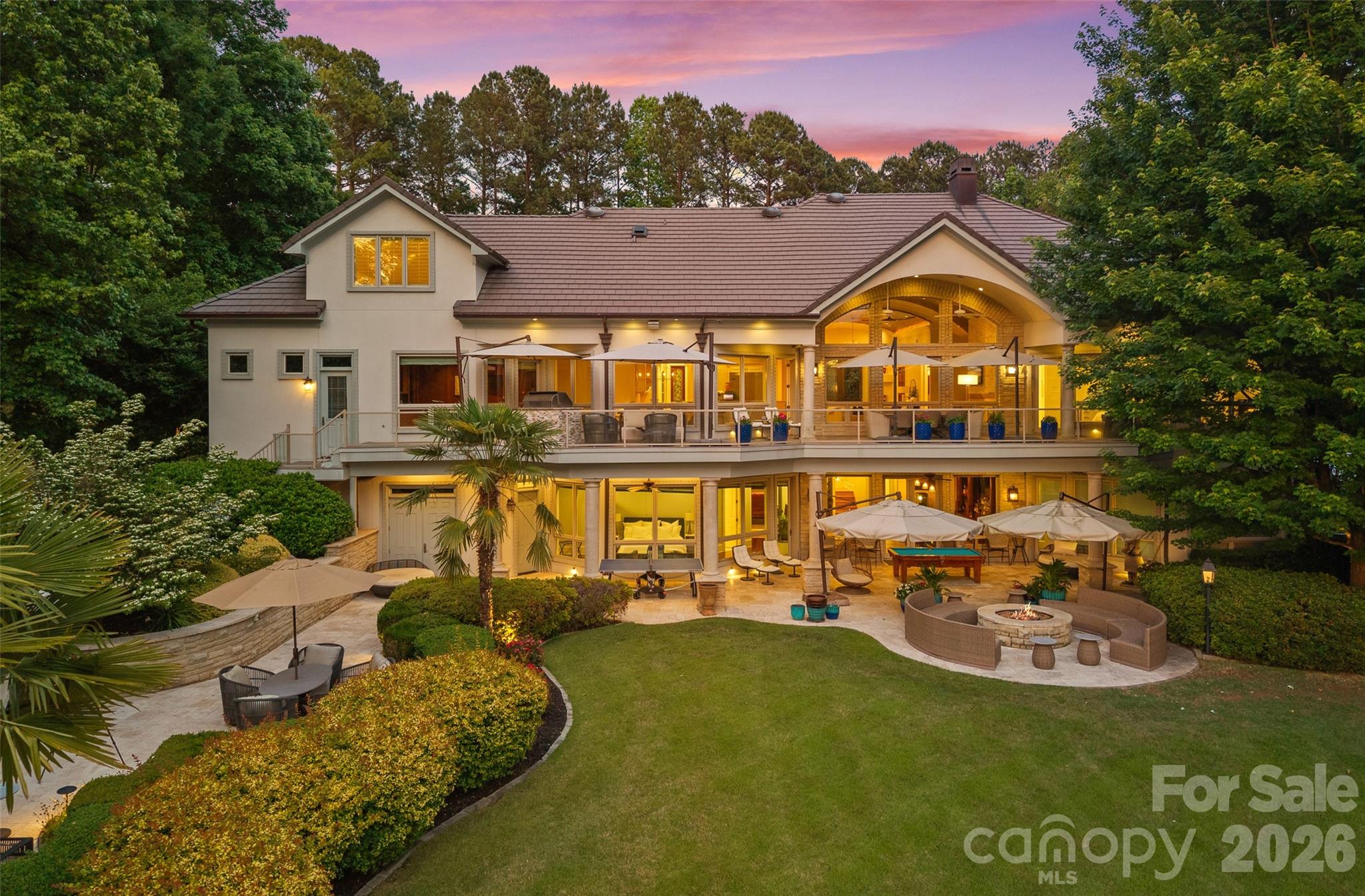 A rare offering. Private, gated waterfront estate with no HOA, delivering a level of luxury, privacy, and lifestyle that is nearly impossible to replicate.
Arrival is unforgettable with a circular drive, statement fountain, and glowing gas lanterns. Inside, walls of glass frame sweeping lake views, setting the stage for a dramatic great room anchored by a striking limestone fireplace. The chef’s kitchen is built to perform and impress, featuring a 10-burner gas range, oversized island, prep sink, and seamless flow to a sunlit dining area and expansive balcony with built-in grill.
The main-level primary suite is a true sanctuary, complete with fireplace, private balcony access, and a spa-caliber bath with heated floors, steam shower, and a custom boutique-style closet with private laundry. A refined executive office with detailed millwork and lake views elevates the everyday.
Designed for exceptional entertaining, the lake level offers a full bar, theater, and wine cellar, opening to a covered outdoor living experience finished in travertine with a built-in firepit, heaters and surround sound. The resort-style pool and spa are thoughtfully positioned off to the side, preserving unobstructed lake views from the main living and entertaining spaces, while a dedicated cabana bath ensures effortless indoor-outdoor lake living. Enjoy a private putting green and a covered dock with deep water access and dual boat lifts.
Multiple guest suites each with en-suite baths provide elevated comfort and privacy throughout.
A true entertainer’s masterpiece, where every detail is designed to impress and every space is built to be experienced.