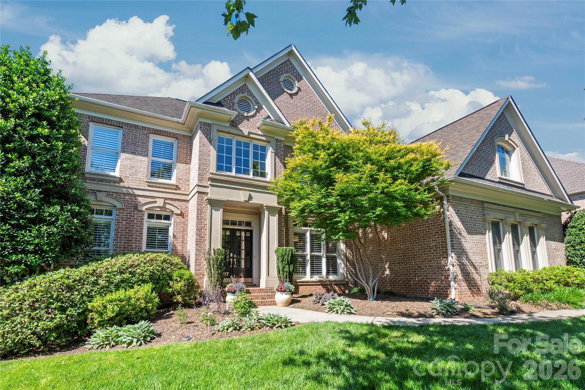 Welcome to a life of unparalleled luxury, comfort, and community in Bridgehampton. From the moment you arrive, this striking, three-sided brick John Wieland "Columbia" plan captivates with its three-car side-load garage and beautiful curb appeal. Step through the grand foyer, where elegant hardwood floors guide you into a bright, open floor plan designed for seamless everyday living. At the heart of the home is a fully renovated chef’s kitchen—a culinary masterpiece featuring custom shaker cabinetry, abundant storage, and a generous central island with a built-in wine fridge where guests will naturally gather. Just beyond, the dramatic two-story great room takes your breath away with its soaring architectural details and expansive picture windows that flood the space with natural light.

The main level offers a rare and incredibly valuable asset: a full in-law suite or teenage hangout suite complete with its own dedicated bedroom, kitchen, living and dining area, and a thoughtful zero-entry shower equipped with grab bars. Upstairs, the luxury continues with four spacious bedrooms, each enjoying direct access to an en suite or Jack-and-Jill bath. The expansive primary suite is a magnificent sanctuary featuring a show-stopping, custom-designed boutique closet (newly completed in 2026) with a center island and glass display cabinets, plus two additional walk-in closets for effortless organization. The third floor delivers ultimate flexibility with a massive recreation room perfect for a home theater or playroom. Peace of mind is built right in, highlighted by updated designer lighting throughout, plush new second-floor carpeting (2025), and completely upgraded plumbing (2025) installed during the suite addition.

Step outside into your private backyard oasis, a meticulously designed outdoor retreat backing up to a lush canopy of mature trees. Perfect for morning coffee or winding down with a glass of wine, this fully fenced entertainer’s dream features a cozy lounge area with an outdoor wood/gas stone fireplace and TV hookup, flanked by a beautiful gazebo. The premium outdoor kitchen is fully equipped with a grill, outdoor sink, and bar area for effortless hosting. Say goodbye to muddy paws and high lawn maintenance—the pristine artificial turf provides the perfect year-round surface for soccer matches, lawn games, or a round of frisbee golf.

Beyond the property line lies a vibrant, active lifestyle where neighbors truly connect. You are just a short walk away from Bridgehampton’s resort-style amenities, including a spectacular pool with a giant spiral water slide, a splash pad, tennis and pickleball courts, a clubhouse with a fitness center, a playground, basketball courts, and scenic walking trails. Best of all, you are situated just 2.4 miles from the premier dining, shopping, and entertainment at the Ballantyne Bowl. This property offers the best of both worlds: a highly coveted Ballantyne lifestyle paired with the advantage of low South Carolina taxes.