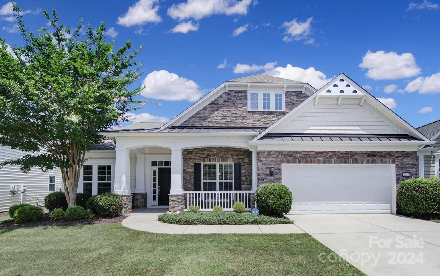 Stunning Morningside Lane w/ a stone veneer exterior & inviting front porch! This home features pre-finished wood floors throughout the main living areas, elegant trim work & wainscoting, upgraded fixtures, and an abundance of natural light. The gourmet kitchen offers beauty w/ ivory cabinets, SS appliances, a large prep island, granite counters, under/over cabinet lighting, & pull-out shelving. Eat meals in the formal dining room or the area off of the great room. Host guests in the great room w/ a gas-log fireplace, or in the spacious sunroom which overlooks the backyard! The primary bedroom has a tray ceiling, and the bathroom offers a dual-sink vanity w/ ivory cabinets, a soaking tub, & a glass encased shower. Relax on the flagstone patio (either under the pergola or the retractable awning) and enjoy the small pond w/ a waterfall & beautiful privacy landscaping. This home has it all! Come join the active adult lifestyle of Sun City today, and enjoy endless resort-style amenities!
