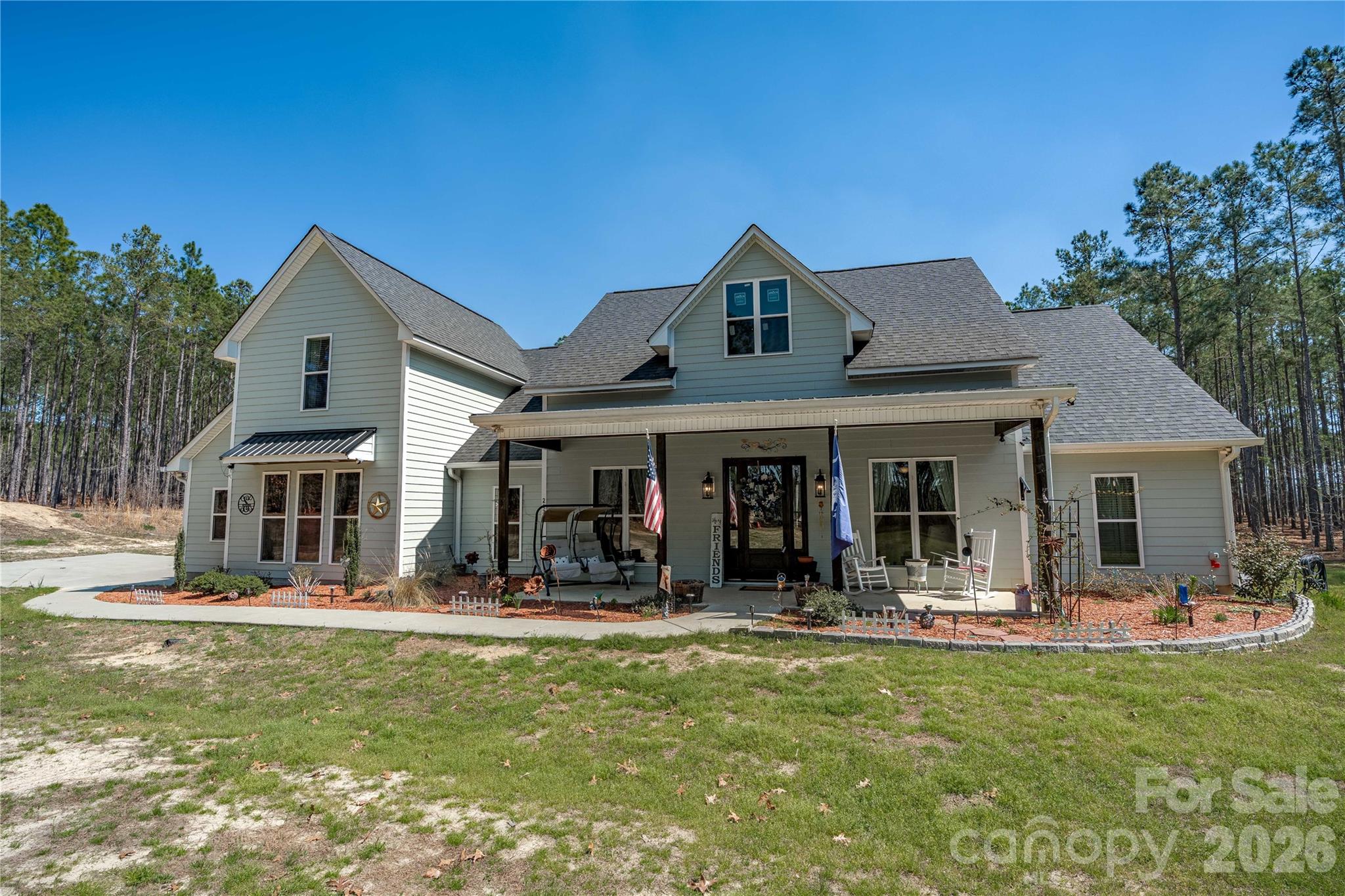 A rare offering—this custom-built modern farmhouse on 4.32 private acres, just minutes from downtown Historic Camden, delivers the kind of craftsmanship, privacy, and quiet luxury that’s nearly impossible to replicate. From the moment you arrive, the expansive covered front porch and striking custom hardwood entry set the tone for what lies beyond.Inside, the home opens to a light-filled, thoughtfully designed layout featuring soaring ceilings, large windows, and refined finishes throughout. The gourmet kitchen is both functional and beautiful, complete with granite countertops, stainless steel appliances, natural hardwood cabinetry with soft-close features, and a butler’s pantry—perfect for entertaining or everyday living.What truly sets this home apart are the custom details you won’t find anywhere else—from hand-cut hardwood moldings to a one-of-a-kind fireplace mantle crafted from a historic local tree over 100 years old, adding warmth and story to the heart of the home.Upstairs, a spacious FROG with a full bath offers flexibility for a private guest retreat, home office, or media space.Step outside and experience your own personal retreat. The covered back patio is designed for relaxing or entertaining, complete with outdoor seating, TV setup, and hot tub—ideal for enjoying quiet evenings under the Carolina sky. The property is also equipped with a dedicated breaker for a future pool, giving you room to expand your outdoor oasis.With over 4 acres, recent landscaping updates, and no shortage of privacy, this property delivers the lifestyle buyers are searching for—space to breathe, room to grow, and a home that is anything but ordinary. Disclaimer:  CMLS has not reviewed and, therefore, does not endorse vendors who may appear in listings.