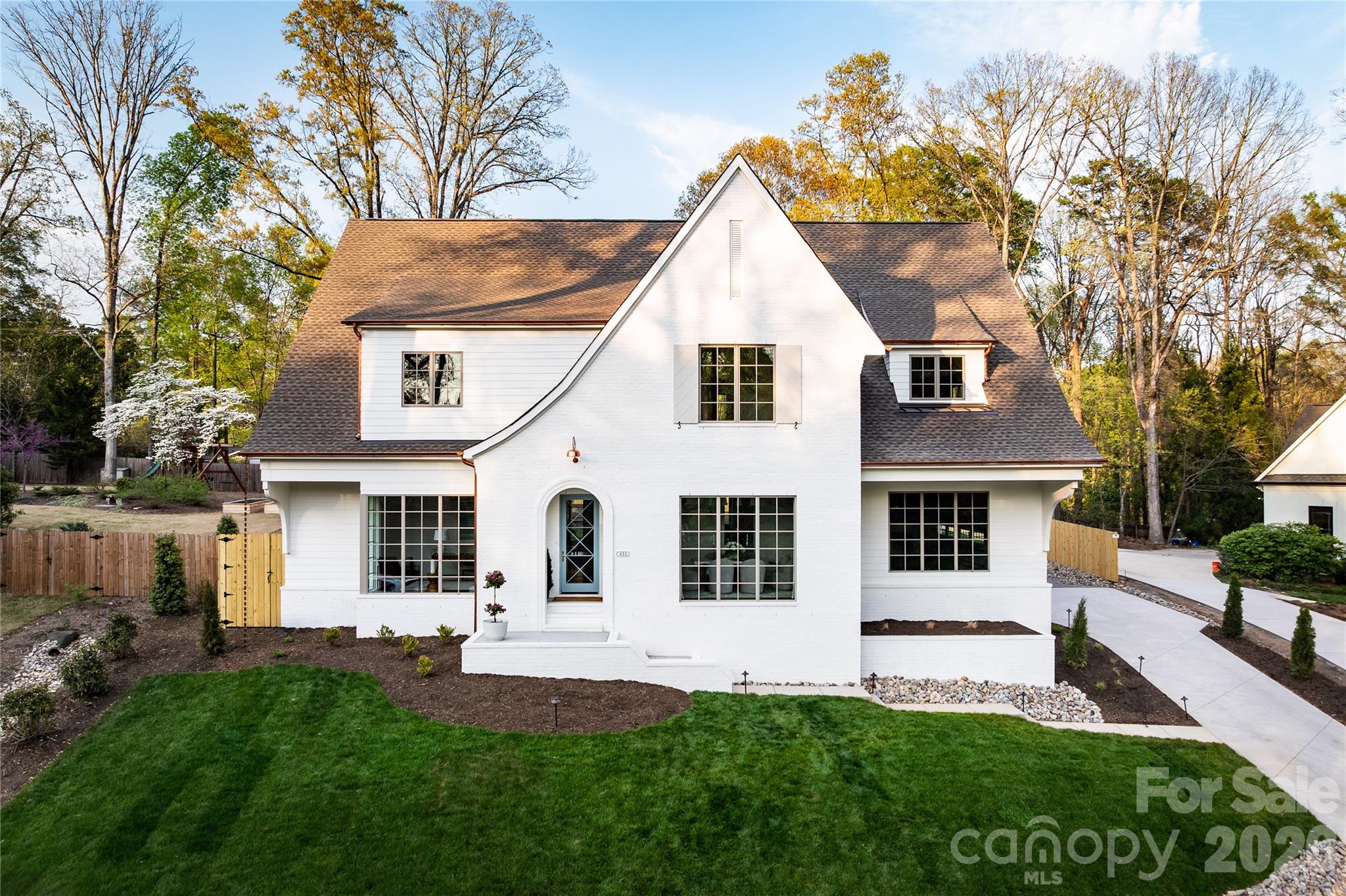 Welcome to this exceptional new construction home by Springdale Custom Builders, thoughtfully positioned at the end of Hunter Lane in Sherwood Forest - one of South Charlotte’s most established and sought-after neighborhoods. Offering convenient access to Uptown, SouthPark, South Charlotte, and the region’s premier hospital systems, this residence pairs location with an uncompromising level of design and craftsmanship.

Set on a private lot, this 4,798+ square foot home is a showcase of refined living, where every element has been intentionally selected and meticulously executed. From the moment you arrive, the architectural presence is undeniable, highlighted by copper gutters, a custom rain chain, designer copper lighting, and custom oversized corbels - distinctive exterior details that signal the level of quality carried throughout the home.

Inside, the layout is both highly functional and beautifully composed, designed to support everyday living while elevating the experience of entertaining. The home features five bedrooms, four full bathrooms, and a powder room, along with a dedicated office, screened-in porch, and a spacious recreation room with wet bar. Each space flows naturally into the next, creating a cohesive and comfortable environment.

At the heart of the home, the kitchen is as practical as it is striking - anchored by an oversized island and complemented by a decorative slab backsplash that creates a clean, elevated focal point. A fully equipped scullery and butler’s pantry provide additional function, with the scullery featuring a second dishwasher, full-size refrigerator, and a large fluted farmhouse sink - ideal for seamless entertaining. Custom cabinetry is thoughtfully integrated throughout the home, paired with detailed millwork that adds depth and character. In the kitchen, scullery, and butler’s pantry, brass cabinet hardware sourced from England introduces a refined, bespoke finish.

Site-finished oak hardwood floors extend throughout, reinforcing the home’s warmth and craftsmanship. The open-concept living area centers around a limestone-surround fireplace with custom built-ins and picture lighting, creating a refined focal point while maintaining a relaxed, livable feel. Large openings lead seamlessly to the screened-in porch, where a dedicated fireplace creates an inviting, year-round outdoor living space.

The dining room and private office are positioned for both functionality and visual impact, each featuring dramatic 8-foot windows that extend to the floor, filling the spaces with natural light and enhancing the home’s architectural presence.

The main-level primary suite is designed as a true retreat, offering privacy, scale, and thoughtful detail. Vaulted ceilings create an airy, elevated feel, while the ensuite bath features custom cabinetry with reeded doors and drawers, bringing a tailored, furniture-quality aesthetic. A zero-entry walk-in shower with a striking tile design completes the space, delivering both luxury and ease of use.

Upstairs, four additional bedrooms and three full bathrooms provide ample space for family and guests. Each bathroom has been individually designed with unique, high-end finishes - ensuring that no space feels secondary. An oversized bonus room offers exceptional flexibility, easily functioning as a media room, fitness space, additional bedroom, second office, or creative studio, complete with a wet bar to support any use.

Every detail of this home reflects Springdale Custom Builders’ commitment to quality, design integrity, and livability. This is not simply a new construction home - it’s a carefully curated living experience in one of Charlotte’s most desirable locations.

Showings begin March 28.