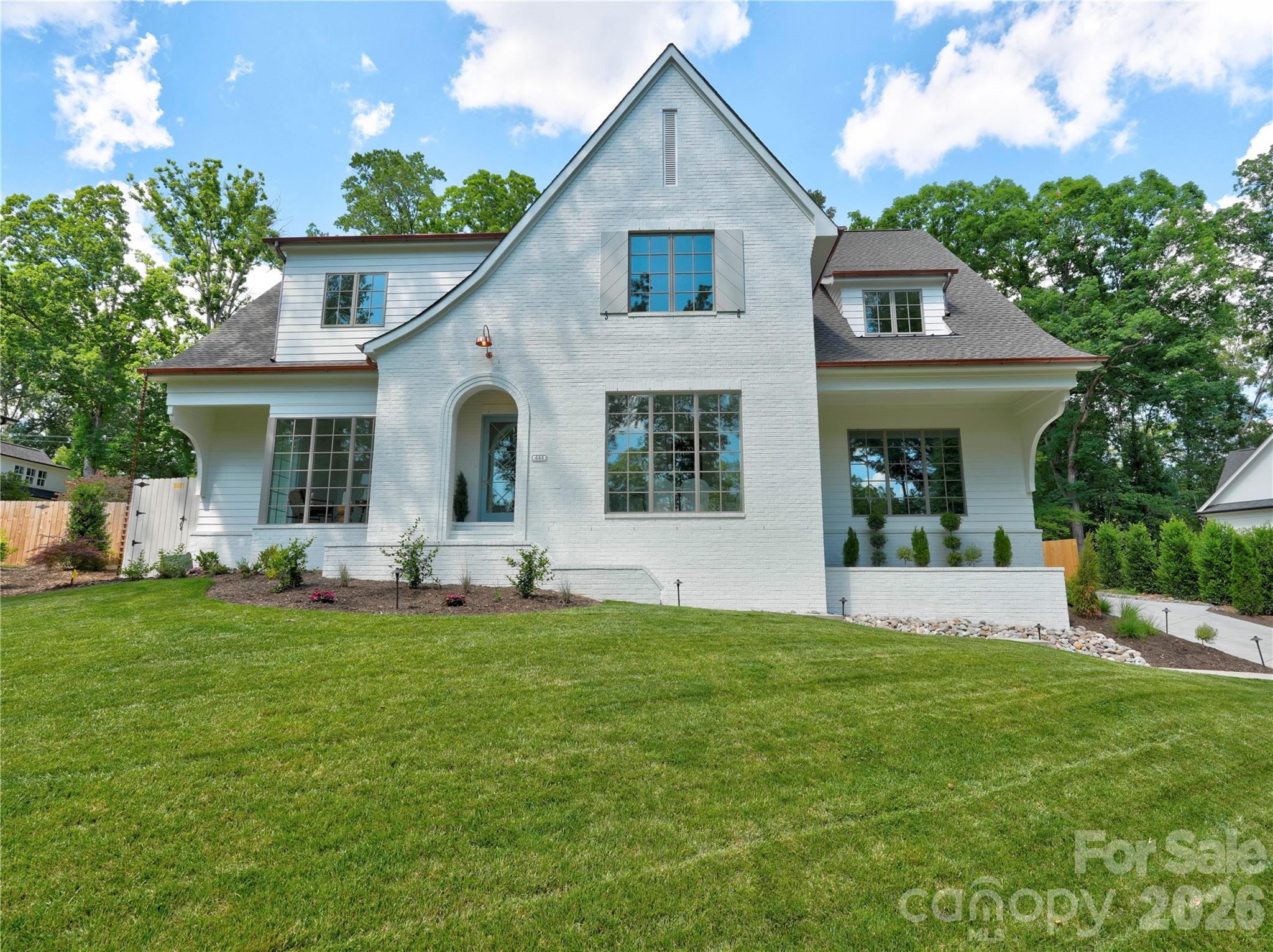 Welcome to this exceptional new construction home by Springdale Custom Builders, thoughtfully positioned at the end of Hunter Lane in Sherwood Forest - one of South Charlotte’s most established and sought-after neighborhoods. Offering convenient access to Uptown, SouthPark, South Charlotte, and the region’s premier hospital systems, this residence pairs location with an uncompromising level of design and craftsmanship.

Set on a private lot, this 4,798+ square foot home is a showcase of refined living, where every element has been intentionally selected and meticulously executed. From the moment you arrive, the architectural presence is undeniable, highlighted by copper gutters, a custom rain chain, designer copper lighting, and custom oversized corbels - distinctive exterior details that signal the level of quality carried throughout the home.

Inside, the layout is both highly functional and beautifully composed, designed to support everyday living while elevating the experience of entertaining. The home features five bedrooms, four full bathrooms, and a powder room, along with a dedicated office, screened-in porch, and a spacious recreation room with wet bar. Each space flows naturally into the next, creating a cohesive and comfortable environment.

At the heart of the home, the kitchen is as practical as it is striking - anchored by an oversized island and complemented by a decorative slab backsplash that creates a clean, elevated focal point. A fully equipped scullery and butler’s pantry provide additional function, with the scullery featuring a second dishwasher, full-size refrigerator, and a large fluted farmhouse sink - ideal for seamless entertaining. Custom cabinetry is thoughtfully integrated throughout the home, paired with detailed millwork that adds depth and character. In the kitchen, scullery, and butler’s pantry, brass cabinet hardware sourced from England introduces a refined, bespoke finish.

Site-finished oak hardwood floors extend throughout, reinforcing the home’s warmth and craftsmanship. The open-concept living area centers around a limestone-surround fireplace with custom built-ins and picture lighting, creating a refined focal point while maintaining a relaxed, livable feel. Large openings lead seamlessly to the screened-in porch, where a dedicated fireplace creates an inviting, year-round outdoor living space.

The dining room and private office are positioned for both functionality and visual impact, each featuring dramatic 8-foot windows that extend to the floor, filling the spaces with natural light and enhancing the home’s architectural presence.

The main-level primary suite is designed as a true retreat, offering privacy, scale, and thoughtful detail. Vaulted ceilings create an airy, elevated feel, while the ensuite bath features custom cabinetry with reeded doors and drawers, bringing a tailored, furniture-quality aesthetic. A zero-entry walk-in shower with a striking tile design completes the space, delivering both luxury and ease of use.

Upstairs, four additional bedrooms and three full bathrooms provide ample space for family and guests. Each bathroom has been individually designed with unique, high-end finishes - ensuring that no space feels secondary. An oversized bonus room offers exceptional flexibility, easily functioning as a media room, fitness space, additional bedroom, second office, or creative studio, complete with a wet bar to support any use.

Every detail of this home reflects Springdale Custom Builders’ commitment to quality, design integrity, and livability. This is not simply a new construction home - it’s a carefully curated living experience in one of Charlotte’s most desirable locations.

Showings begin March 28.