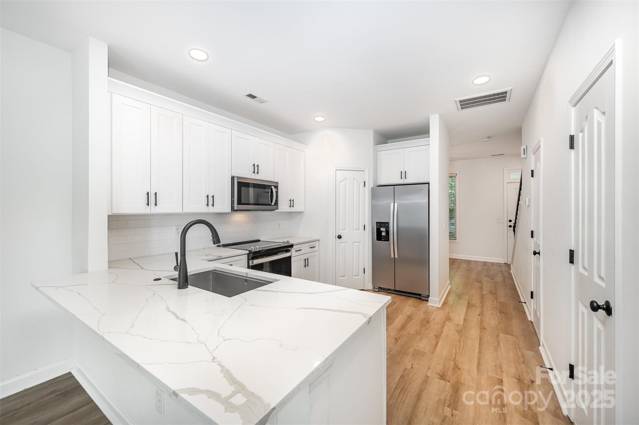 Step into this beautifully renovated townhome in the heart of Baxter Village, where the standout feature is a fully remodeled kitchen with stylish finishes that make everyday living feel elevated. The open layout on the main floor flows from the kitchen into a bright living area with a cozy fireplace and out onto a spacious new deck—ideal for entertaining or relaxing outdoors. Recent updates throughout the home include new flooring, fresh paint, and two updated bathrooms, giving the entire space a fresh, move-in ready feel. Upstairs, both bedrooms feature en-suite baths and walk-in closets, with laundry conveniently located between them. Outside, enjoy a private fenced yard and detached garage with alley access. With its thoughtful updates and unbeatable location just steps from restaurants, parks, and top-rated schools, this home is ready for you to settle in and enjoy the Baxter Village lifestyle.