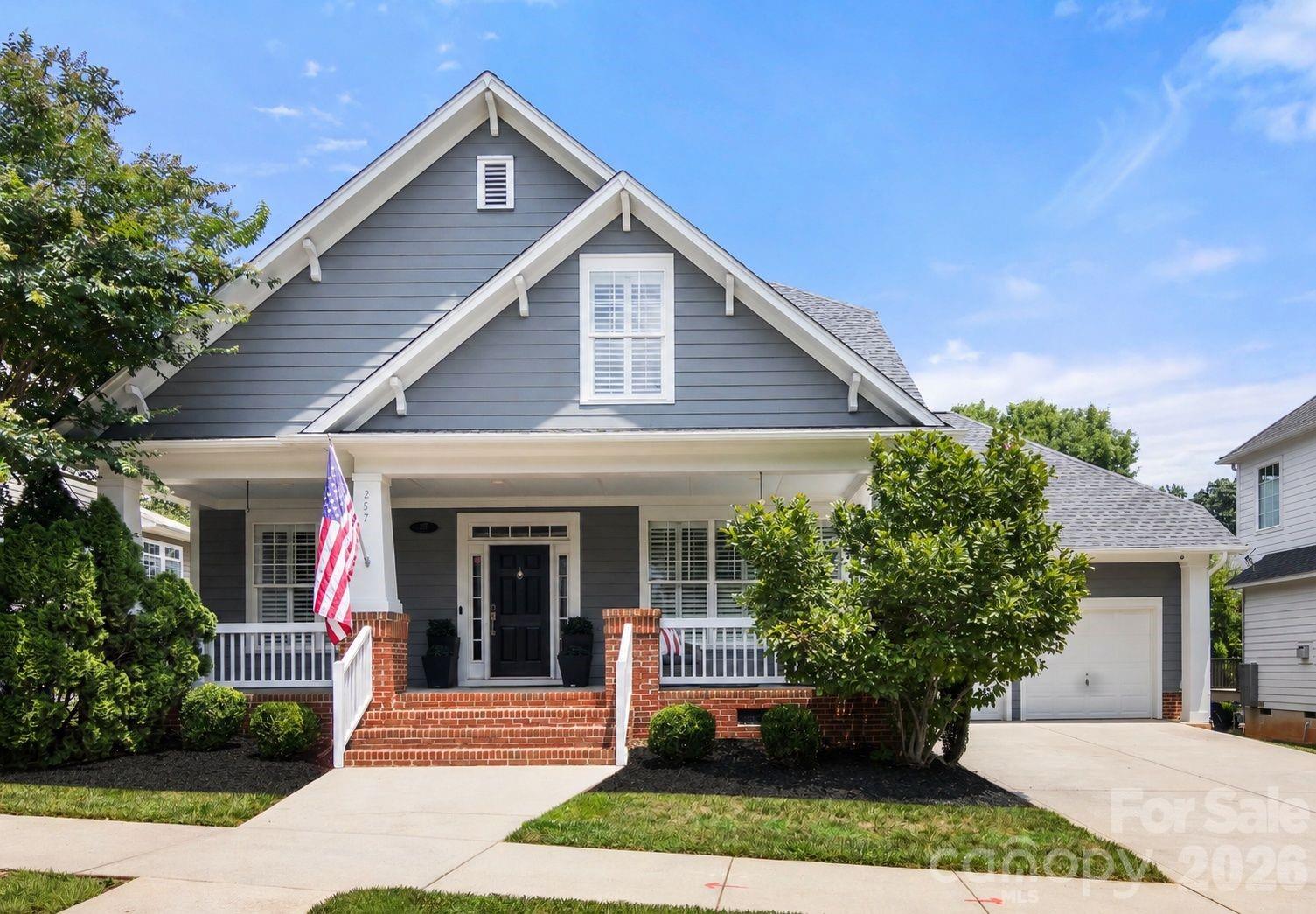 Timeless Davidson charm meets beautifully updated interiors at 257 Harper Lee Street. Located in the desirable New Neighborhood/Old Davidson community, this 2,566 square foot home offers an ideal blend of character, comfort, and convenience with the primary suite on the main level. Thoughtfully designed by a local interior designer, this turn-key, move-in ready home is filled with curated updates and stylish finishes throughout. A welcoming covered front porch sets the tone, opening to hardwood floors, tall ceilings, plantation shutters, custom trim details, and upgraded lighting. The main living spaces are designed for both everyday living and entertaining, featuring a private office with French doors, formal dining room, open great room with soaring ceilings and fireplace, and a stunning updated kitchen with two-tone cabinetry, stainless steel appliances, gas range, stylish backsplash, open shelving, pantry, and island seating. The main-level primary suite feels like a retreat with a beautifully renovated bath, dual vanity, soaking tub, tiled walk-in shower, and custom walk-in closet. Upstairs includes two spacious bedrooms, full bath, loft/flex space, and attic storage. Relax outdoors on the private rear deck overlooking the mature, landscaped yard. Just minutes from downtown Davidson, parks, dining, shops, sidewalks, and neighborhood walking trails.