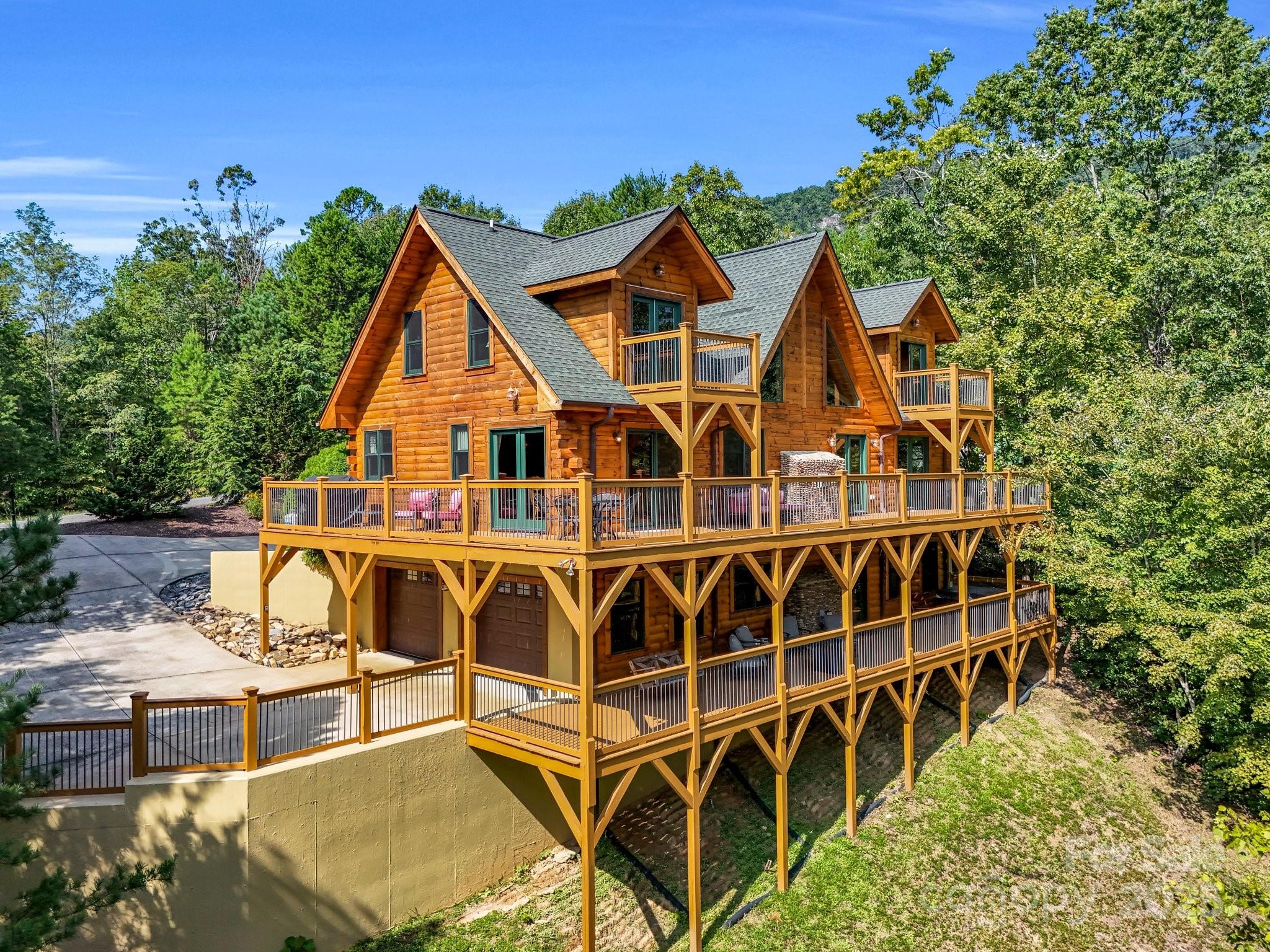 Classic log cabin, conveniently located behind the gates of Rumbling Bald on Lake Lure and just a short golf cart ride to amenities. The main level features a cathedral ceiling great room with a river rock stone gas fireplace, a fully equipped kitchen with granite countertops, SS appliances, breakfast bar, walk-in pantry, and laundry room. The primary en-suite bedroom, and guest half bath are also on the main level. Upstairs you’ll find 2 more guest bedrooms and a full bath. The walkout finished basement boasts a 2nd living room with another stone fireplace, kitchenette, another bedroom and full bath. The 1.5 car garage has been finished and converted into a game room with foosball, tabletop shuffleboard, air hockey, pinball, basketball, and much more! Exterior recently sealed & stained. Some amenities include 24-hour security, lake access, private beach, indoor/outdoor pools, pickleball, tennis, two 18-hole championship golf courses, fitness center, spa, restaurants & bars.
