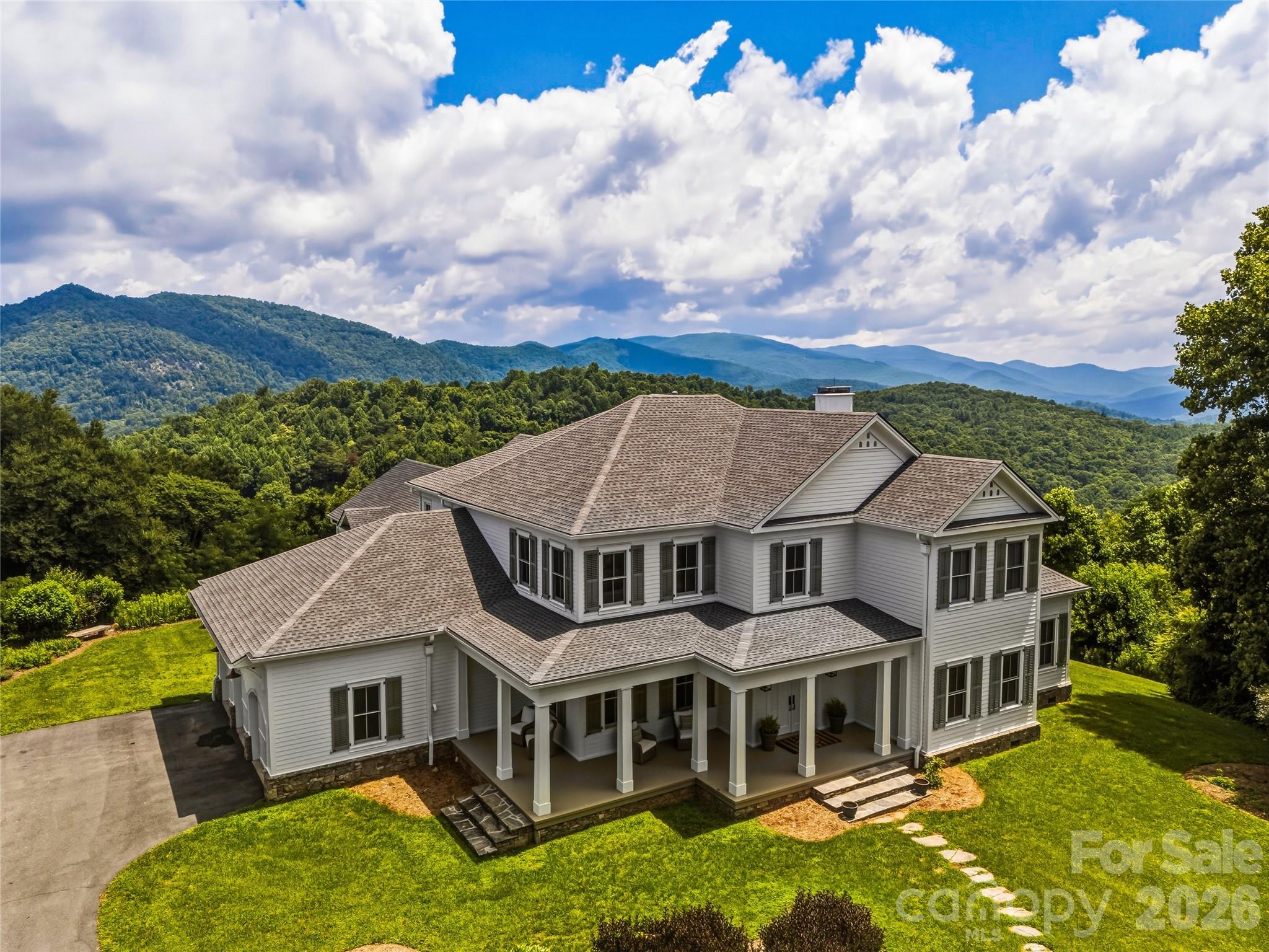 Some homes make you stop the moment you arrive. This is one of them.
Tucked within the gated, tree-canopied enclave of Butler Mountain Estates, in Fairview, NC, just minutes from Asheville and the scenic Blue Ridge Parkway, is a 5-bedroom, 4.5-bath mountain estate where the views never end, in any season. Endless long-range mountain panoramas greet you from nearly every window, and from the covered rocking porches, where you can simply sit, breathe, and take it all in.
This is a legacy home in every sense of the word.
The current owners have poured intention into every detail since acquiring the property in 2022. The interiors were completely reimagined, with each space thoughtfully curated to reflect a sophisticated, refined aesthetic. The exterior was freshly painted this year, and the flat driveway, a rarity at this elevation, welcomes you home effortlessly.
At 6,292 square feet on nearly 5 private acres, the scale is commanding without sacrificing warmth. Three fireplaces - one in the living room, one in the family room, and one in an upper-level bedroom ensuite - create an atmosphere that is as intimate as it is impressive. Two primary ensuites on the main level offer flexibility and privacy for multigenerational living or discerning guests. A private main-level office, formal dining area, and an abundance of closet and storage space throughout speak to a home designed for real life, lived beautifully.
An enormous floor-to-ceiling cabinet pantry with a dedicated refrigerator opens directly to a grilling porch, making entertaining and hosting a seamless experience.
The upper level is a world unto itself. A magnificent great room features a kitchenette, a pool table, a generous sitting area, and a library alcove framed by custom built-ins. Flooded with natural light, it is equally suited as an art studio, a creative retreat, or simply the room everyone gravitates toward.
Butler Mountain Estates offers something increasingly rare: a walkable, neighborly community within a gated setting, crowned by a 5-acre common recreation area at the mountain's summit with views that stretch to the horizon.
This is mountain living at its most elevated.