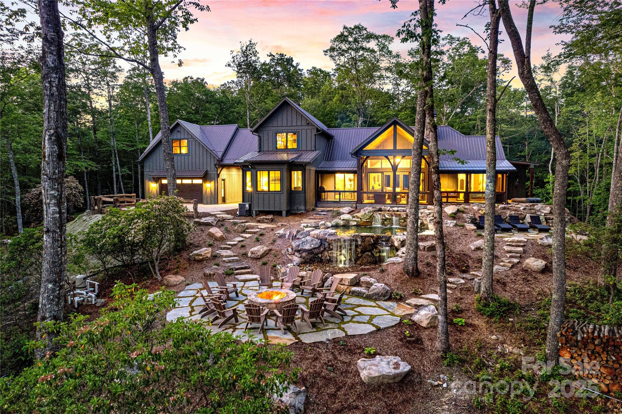 Experience Alpenglow Falls—a one-of-a-kind luxury mountain retreat set on 5.6 private forested acres with the rare convenience of being in town. Purposefully oriented to capture both sunrise and sunset over Whiteside Mountain, this 5,100+ sq ft residence offers breathtaking views, total privacy, and seamless indoor/outdoor living. Designed for relaxation and entertaining, the open floorplan features cathedral ceilings, expansive living and dining spaces, a gourmet kitchen, spa-style primary suite with sauna and indoor/outdoor shower, and multiple custom lounges including a vintage parlor, underground speakeasy, and third-level recreation loft. Outdoor living is extraordinary with screened porches, fireplaces, star-gazing fire pit, natural water features, and direct access to private hiking trails. Built as a luxury escape with resort-level amenities and year-round appeal, this property offers exceptional potential as a premier vacation rental, second home, or private estate in one of the most desirable mountain locations.