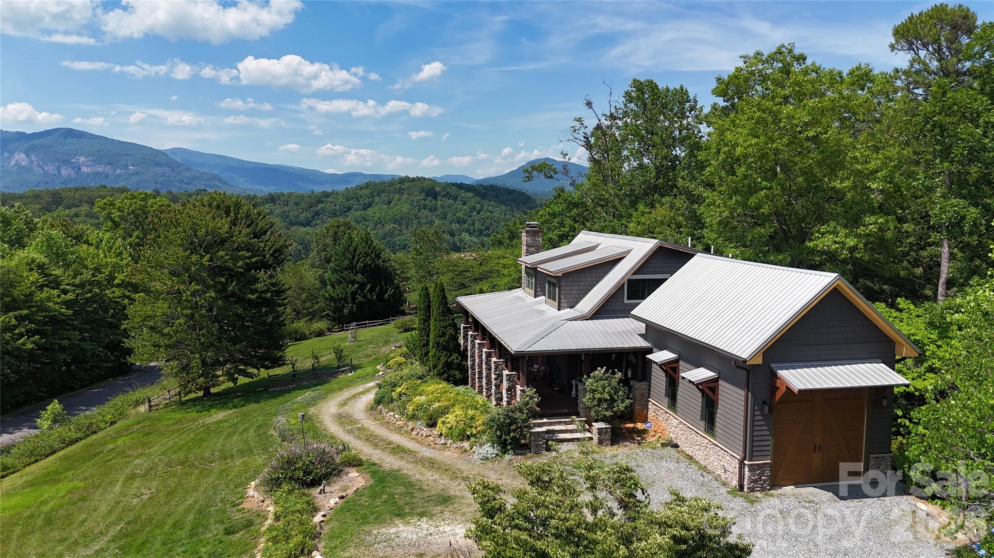 Morning coffee with the mountains, dinner at sunset, curled up among the trees with a book, or scrolling social media on the deck pretending to be productive—your call! No judgement! :)
Sitting amazingly perfect on 4.28± ACRES!

Welcome to 301 Peaks Drive—beautifully crafted, MOVE-IN READY mountain cabin perched in The Peaks of Lake Lure, one of the area’s most sought-after gated communities with it's ease of access and killer views!!! Known for its serenity, paved roads, gentle access (no steep mountain climbs here!), and long-range Blue Ridge VIEWS, this is a top pick for anyone wanting the perfect blend of privacy, beauty, and convenience. 

AMAZING MOUNTAIN VIEWS - This home makes you stop and say, “Wow,” each time you walk through the door as sunlight pours in the windows and an inviting floor plan with vaulted ceilings, warm wood accents, and expansive windows framing those year-round ridgelines like moving artwork! The cozy stone fireplace centers the living room, while the kitchen and dining flow right out to the expansive deck, also! Comes with 2 - one car garages - 1 for each "living area" - car enthusiasts or for a second living quarters, it can be offered or finished out... your choice!! 

Another huge perk - The separate 2nd living quarters, complete with its own private entrance and its own garage/parking area. Perfect for guests, multigenerational living, or an income-producing rental, this setup offers incredible flexibility. It has its own easy pull-up access. (***Previously rented out prior to these owners)

Outside, enjoy wooded privacy, room to explore, and a quiet yet babbling creek at times along the lower property line. You might never make it down that far, though—because the front porch and decks offer such extraordinary, peaceful vistas that you’ll feel completely wrapped in the mountain backdrop, soaking in unobstructed views. Come see for yourself! 
(*Appointment required—gated community; must be accompanied by an agent.)

Whether you're searching for a full-time home, a mountain getaway, or a smart investment, 301 Peaks Drive delivers unbeatable Mountain Views, natural light, thoughtful design/layout + 2nd Living Quarters, and one of the best locations Lake Lure has to offer - for your quick access or private seclusion! See what the fuss is all about! 

Also, surrounded by Western North Carolina’s incredible outdoor recreation, you’re just moments from Chimney Rock State Park, Lake Lure, and year-round adventures if you decide to venture out! Travel is easy too, when you come in or have family/friends visiting —about 1 hour to AVL and GSP airports, and roughly 1.5–2 hours to the Charlotte area (CLT International) Homes here don't last long, and thanks to the combo of quiet living, gorgeous scenery, and being only minutes to shopping, dining, and Lake Lure’s best attractions, along with all this home offers...