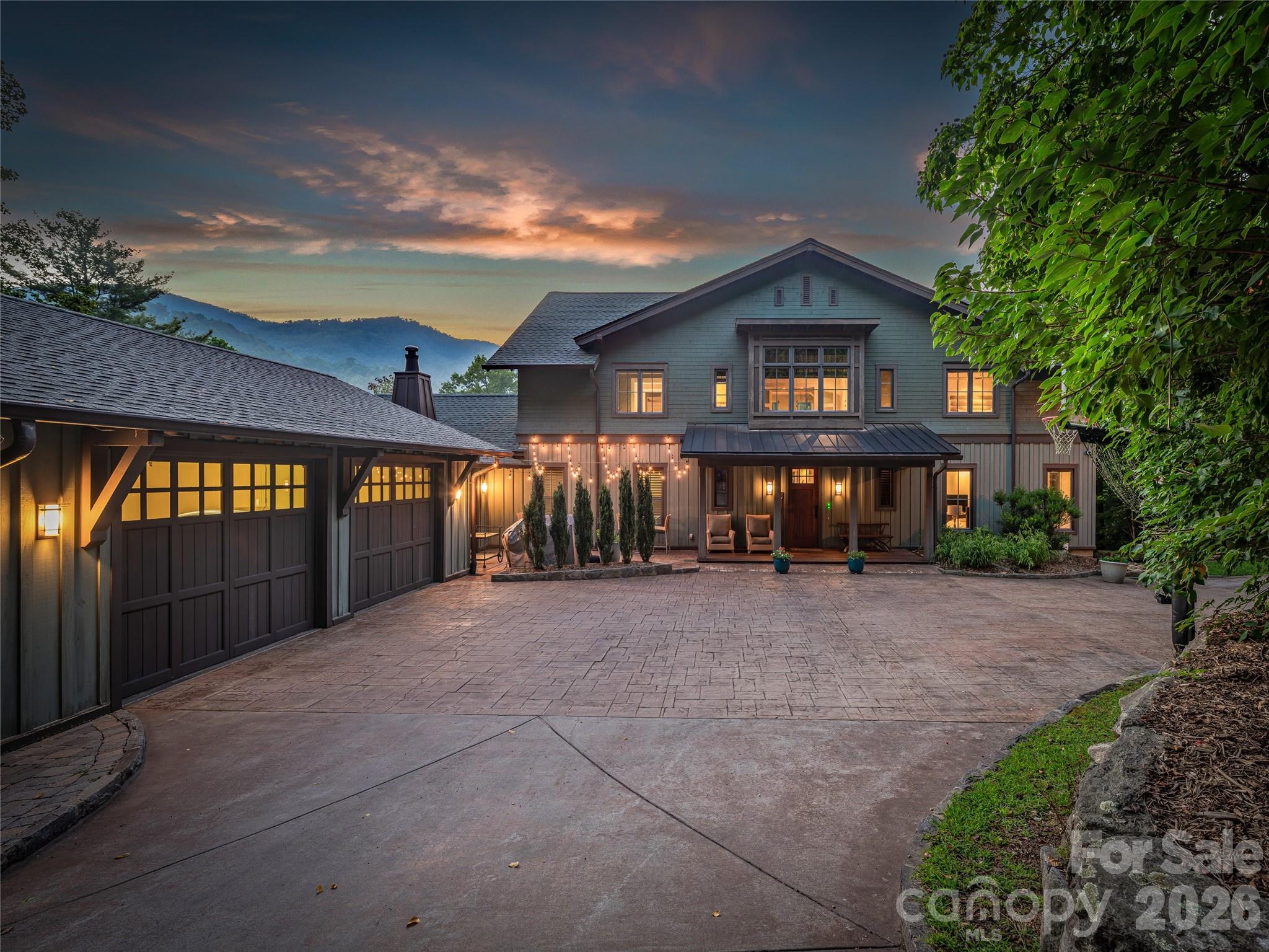 39 Oxbow Crossing is the rare estate that delivers on every level — architecture, land, location, and lifestyle — without a single compromise.
Set on a private 2.29-acre home site within the coveted Oxbow Crossing community, the property also includes an additional 2.97-acre lot, bringing the total holding to over 5 acres of Blue Ridge mountain landscape just 20 minutes from Downtown Asheville. Whether you protect it as a private buffer, explore future use, or simply own the view, the additional land elevates this offering.
The home itself — over 6,000 square feet of contemporary architecture — was built around soaring ceilings, walls of glass, and sweeping mountain vistas, making every room feel connected to the landscape. Custom metalwork, clean architectural lines, and refined materials give the home a sophisticated design language that is both modern and enduring.
The chef's kitchen is in a class of its own: Gaggenau double ovens and gas range, Sub-Zero refrigeration, a wood-fired EarthStone pizza oven, built-in Miele coffee station, soapstone and stainless countertops, and a walk-in pantry that will stop every serious cook mid-tour. It flows naturally into the living and dining areas and out to a covered terrace framed by layered mountain views — the kind of space that makes entertaining feel effortless.
The main level offers a large en-suite bedroom and adjacent office that can be combined into a stunning main-level primary suite, and the home is framed for an elevator-ready future accessibility or multigenerational living. Upstairs, an open gallery overlooks the great room, while the primary suite features a spa bath with a soaking tub, walk-in shower, double vanities, and a custom closet. Two additional en-suite bedrooms, a sitting room or studio, and a full laundry room round out the upper level.
The daylight lower level adds a second living area, guest suite, billiards room, custom bar, fitness space, and an oversized workshop — purpose-built for woodworkers, artists, or anyone who wants room to pursue what they love.
Three-zone HVAC, dual tankless water heaters, gigabit Ethernet, a whole-house generator, and an EV-ready two-car garage ensure the infrastructure matches the architecture.
Minutes from Weaverville, the Blue Ridge Parkway, and Asheville's acclaimed dining and arts scene — yet entirely private and removed from the noise.
This one has to be seen. Schedule your private showing today.