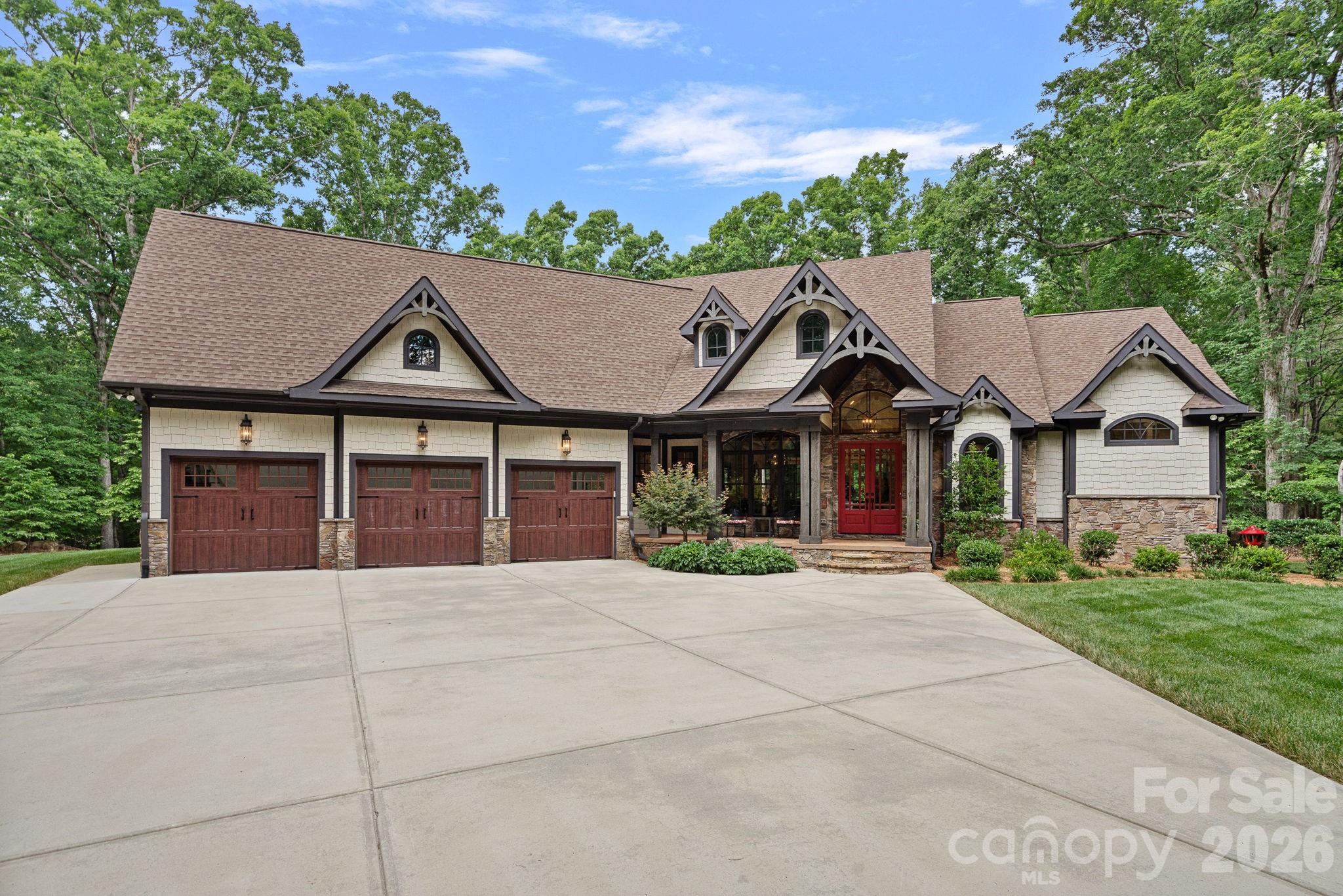 Welcome to your private retreat! This custom built home is truly special, nestled into the woods offering extreme privacy and endless opportunity for outdoor activities. As you progress down the driveway, the home is revealed to you - and the timber details and the wooded setting give it a "lodge" feel. The seller calls the great room "the lodge room" as the wooden arches and brackets continue in the ceiling details, the columns, and the in the heavy timber mantel. A stacked stone fireplace brings a warm a cozy feeling to a room that has soaring vaulted ceilings. If you are looking for a home with a "wow" when you greet your visitors, this is it! As you walk in the front door, and see the rafter details carrying all the way through to the back porch, and a full glass view framing the lush woods beyond - it is impressive! The kitchen is warm and inviting with tall cabinets, a side area that could be used for a coffee station or a bar, and is open to the casual living room space, called the keeping room. There is both bar seating and a breakfast room. Both the Lodge Room and the Keeping Room have built-in cabinets and the ceiling heights vary but are soaring on the first floor! The layout is designed for mostly one-floor living. The primary is on one end of the home, two bedroom suites are conveniently located on the other end. The first floor has a full office plus a built in work desk near the kitchen, plus laundry, mudroom, a casual keeping room living space, dining, breakfast room, and multiple porches. Upstairs is a landing - perfect for yoga or reading, a full bath, and a large bonus room. This space has a closet, and with a full bath upstairs it could make an ideal guest suite for longer visits! Connected to the rec room is another 'flex space" that could be an office, additional closet, or exercise room. It is currently furnished with two matching bunk bed sets. There is also a large walk-out attic space for easy storage. The porch spaces are spectacular - there is a rocking chair front porch, a screened back porch - perfect for al fresco dining- and a grand open back porch. The large porch echoes the vaulted ceiling found in the lodge room, and has a wood burning stone fireplace with a gas starter, and a built-in grill, outdoor sink, and mini-fridge. There are built-in speakers found in most of the rooms, and a video security system that will remain with the home.  The crawl space is conditioned, and there is a hot water line run to the three-car garage for a future dog washing station. A portion of the back yard is fenced, and the beyond the fencing is the well house which offers ample space for the equipment and mirrors the style of the house. Sellers dug a 400' deep well, and installed a salt filtration system and UV light filter that are professionally maintained annually. The previous owners lived toward the front of the property, set a short distance from the current home. The electrical supply, well, and septic systems are all still in place should you want to add additional structures. The doors were built to accommodate a wheelchair, and the primary shower is curbless for easy access. There are both his & hers vanities, his & hers closets, and his & hers ends of the shower! The primary bedroom ceiling has a beautiful wood detail, and the windows overlook the back yard and woods beyond. This is the kind of home that you need to see to appreciate. It has the kind of quality construction that you can feel when you visit - and you will not want to leave! Convenient to downtown Waxhaw, and the JAARS flight facility.