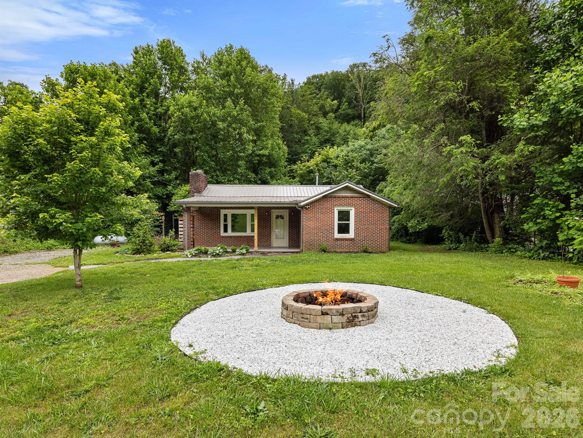 This 2-bedroom, 1-bath cottage in Fairview, North Carolina checks all the boxes. The big kitchen gives you plenty of room to cook and entertain, and the spacious bedrooms are a rare find for a cottage of this size. A wood-burning fireplace ties the living space together and keeps things warm and cozy year-round.
Step outside and you've got a private fire pit surrounded by some of the best mountain views Fairview has to offer. Whether you're starting the morning with coffee on the porch or ending the evening by the fire under the stars, this property delivers the kind of outdoor living that's hard to find at any price point.
Fairview sits just minutes from Asheville but offers the peace and quiet that most people move to Western North Carolina for in the first place. The combination of interior comfort, outdoor space, and unbeatable views makes this one stand out.