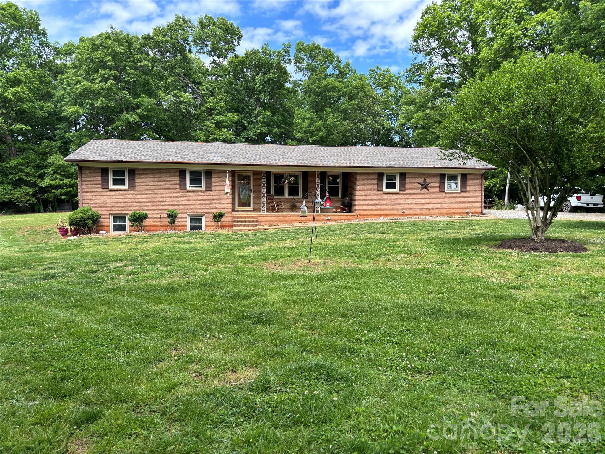Check out this stunning ranch house with a full basement and 4.631 acres of level part wooded property at the end of this quiet private street. Own this piece of Heaven in the foothills of Alexander County.  Bring all your cars, hobbies, and animals because there is plenty of space for all your needs.  This beautiful property has an additional lot with an older well, septic tank, & power, a RV Metal Shed with 50 amp connect, a storage building with power, and an additional metal shed.  The house has many updates which include a new roof in 2025, a new HVAC heat pump system in 2023, and updated bathrooms.  The house has a brick fireplace in the basement area with a wood stove for additional heat, a concrete pad on the rear & a concrete front porch for all your outdoor entertaining. Not another one on the market and this property will not last long.