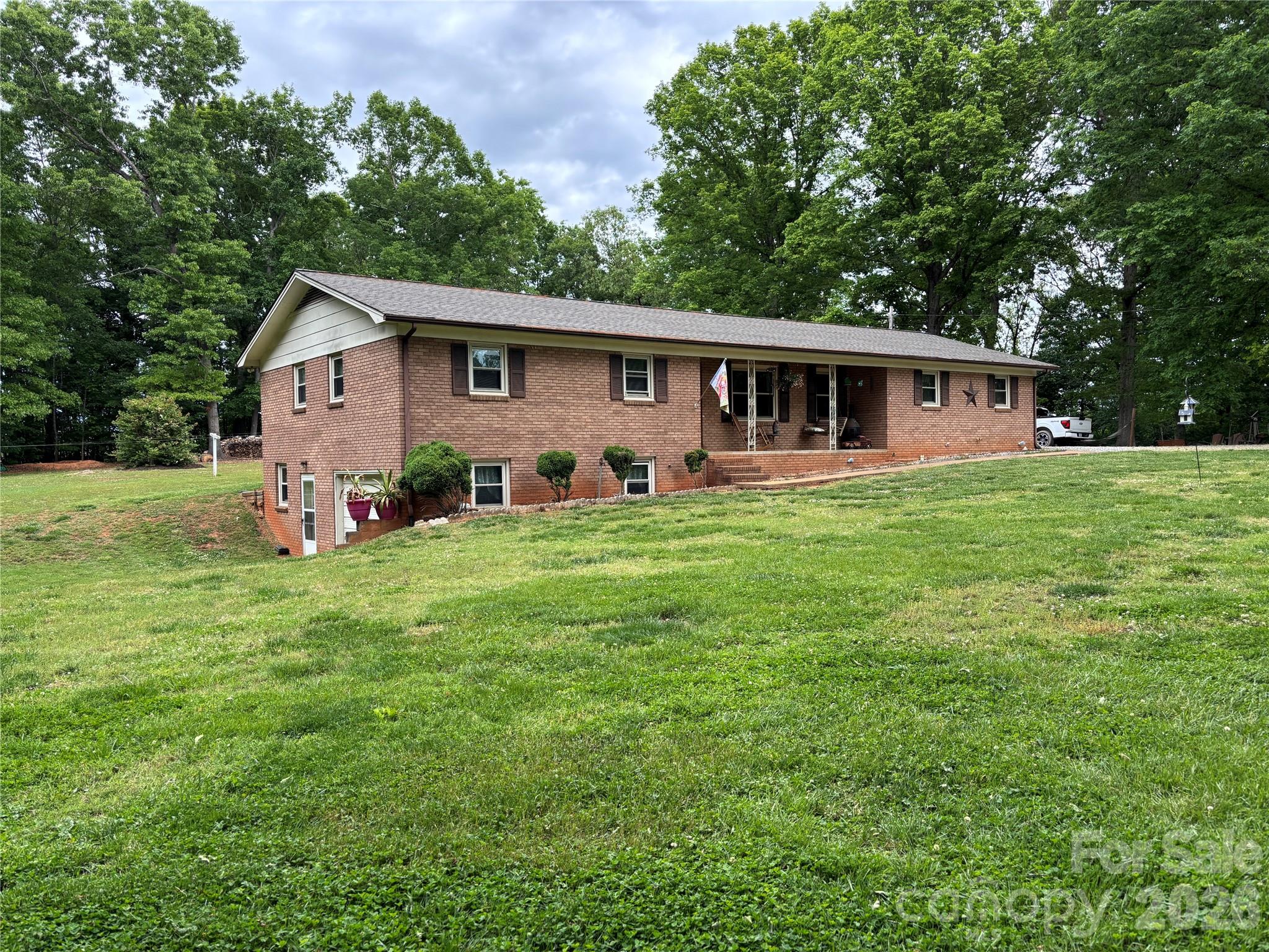 Check out this stunning ranch house with a full basement and 4.631 acres of level part wooded property at the end of this quiet private street. Own this piece of Heaven in the foothills of Alexander County.  Bring all your cars, hobbies, and animals because there is plenty of space for all your needs.  This beautiful property has an additional lot with an older well, septic tank, & power, a RV Metal Shed with 50 amp connect, a storage building with power, and an additional metal shed.  The house has many updates which include a new roof in 2025, a new HVAC heat pump system in 2023, and updated bathrooms.  The house has a brick fireplace in the basement area with a wood stove for additional heat, a concrete pad on the rear & a concrete front porch for all your outdoor entertaining. Not another one on the market and this property will not last long.