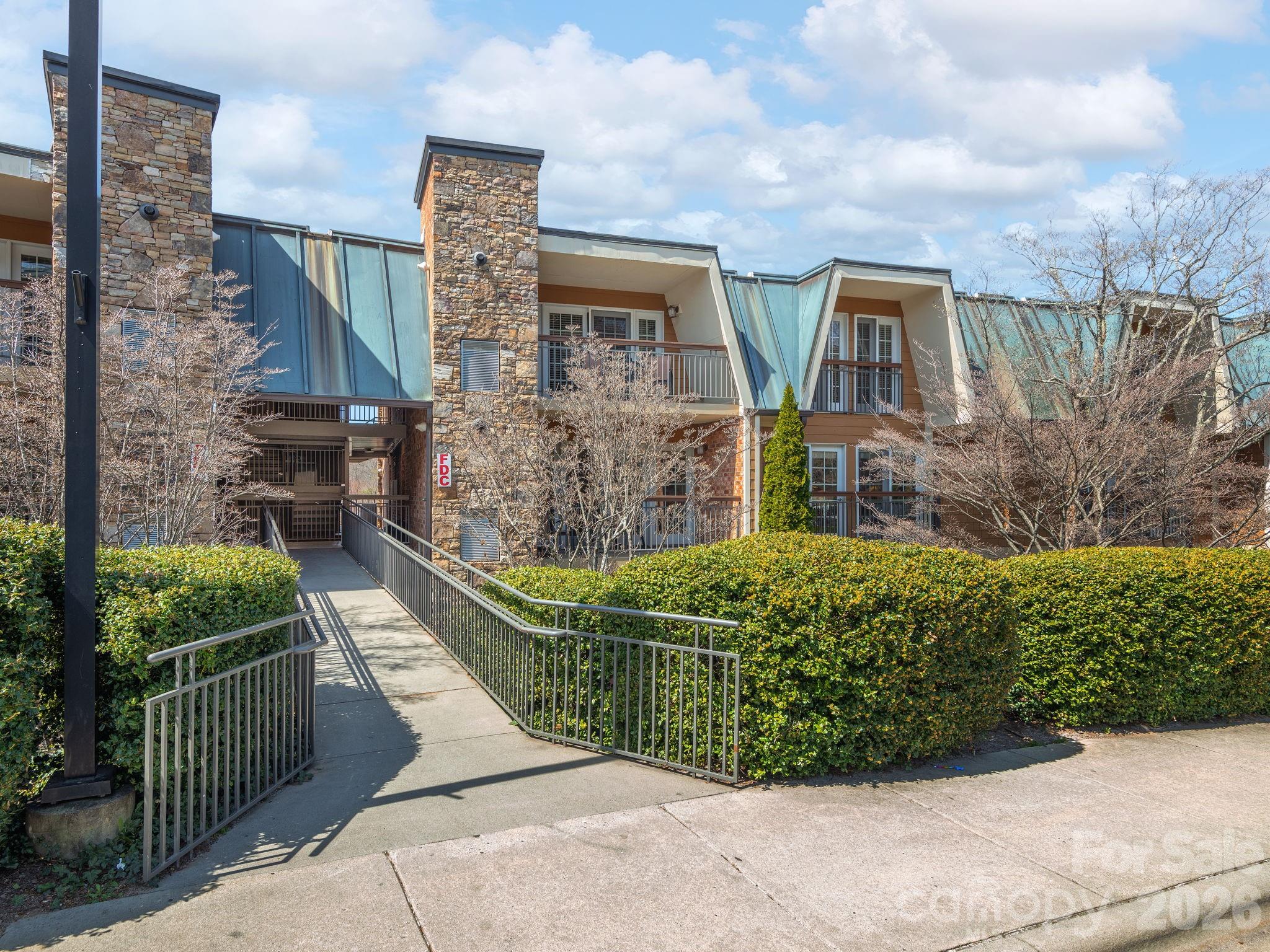 Welcome to The Lantern Lodge: Asheville's concierge condominium community where effortless ownership meets unbeatable location. This unit has easy main-level access with no stairs, making it as accessible as it is convienent. Enjoy the best of both worlds: use it as your personal Asheville getaway whenever you like, then let the professional on-site management company handle everything else, including short-term rental income when you're not here. It's second-home ownership without the hassle. Open floor plan with wood floors in the main living area. Kitchen with granite counters, stainless appliances. Large primary suite with tile and glass shower. Gas fireplace in living area, balcony for enjoying the outdoors. Storage closet for owners. Enjoy the pool, hot tub, and fitness center as well! All furnishings and linens included with the sale. The location is simply unmatched: minutes to Downtown Asheville, the iconic Biltmore Estate, the charming boutiques and dining of Biltmore Village, and the galleries and studios of the River Arts District. Everything that makes Asheville extraordinary is right at your doorstep.