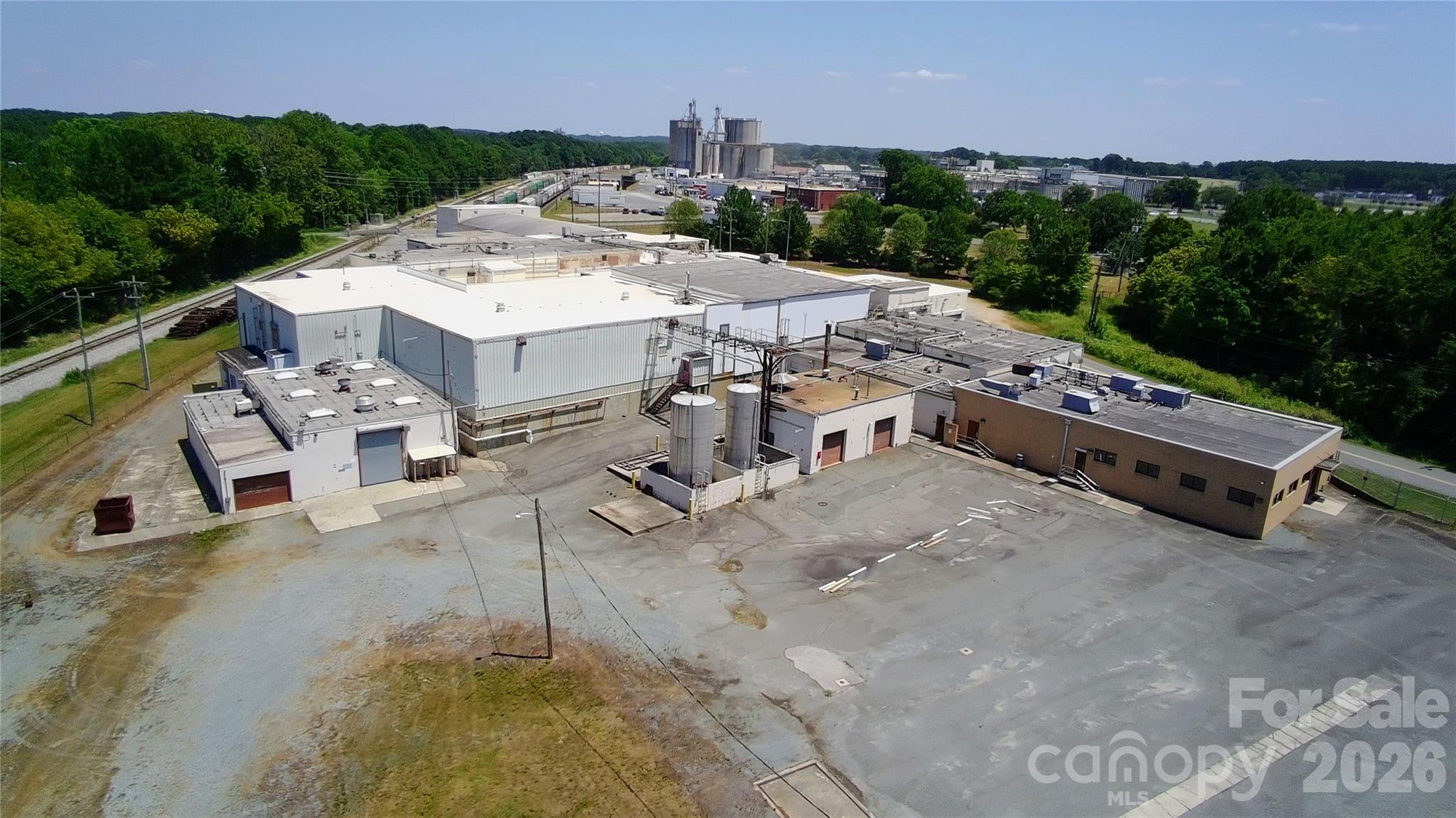 ±87,500 SF food processing and cold storage facility situated on approximately ±30.50 acres in the heart of Monroe’s established industrial corridor. The property is zoned General Industrial (GI) and is positioned directly adjacent to Tyson Foods’ major production complex, placing it within one of the region’s core food processing clusters.

Originally constructed in 1950 and significantly renovated in 2019, the facility was in active use until approximately August 2023 and was previously USDA inspected and SQF Edition 8.1 certified during prior operations. The building layout supports cold production, packaging, staging, ambient storage, dry storage, and secured caged storage areas, in addition to office space, locker rooms, restrooms, and a breakroom/canteen.

Cold storage infrastructure includes renovated freezers and coolers (approximately 2019) utilizing KeepRite refrigeration systems. Ceiling heights range from approximately ±10’ to ±21’ clear. The facility is served by robust 277/480V three phase power with one 1,000 kVA pad mounted transformer and two 2,000 kVA platform mounted transformers. Both wet and dry sprinkler systems are in place.

Loading configuration includes six dock high doors (8’ x 8’), consisting of three cold receiving and three shipping docks, along with two drive in doors at the compactor room. Covered truck bay and canopy structures provide additional staging and service flexibility. The site is fully fenced with an electronic vehicle gate at the entrance.

A significant differentiator is the onsite industrial wastewater treatment system with a capacity of approximately 1,000,000 gallons per day (four 250,000 gallon cycles per day), designed to treat water prior to discharge into the municipal system. City utilities include water, sewer, natural gas, and electricity.

In addition to the main building, the property includes a detached maintenance building with drive in access and a separate boiler/storage building (boiler currently inoperable), also with drive in access. An active rail line runs along the rear boundary of the property and potential spur access may be feasible, subject to verification.

Of the ±30.50 acres, approximately eight acres are developed with the balance primarily wooded. The site includes remnants of historic foundations from a former World War II prisoner of war camp. The property is subject to recorded easements and encumbrances including municipal easements, utility rights of way, railroad access, mineral and riparian rights, and related matters as reflected in public records. Buyer to verify all information, systems, measurements, certifications, utilities, and equipment functionality.

Located approximately four minutes from Highway 74, the property offers convenient access to Charlotte and Wilmington with minimal congestion for truck traffic. Union County Economic Development has historically supported industrial operations in this corridor and incentive programs, including potential property tax rebates for qualifying employers, may be available.

This offering presents a rare opportunity for an owner user seeking a purpose built food processing and cold storage facility with substantial utility infrastructure already in place, or for an investor seeking a specialized industrial asset with long term repositioning potential.