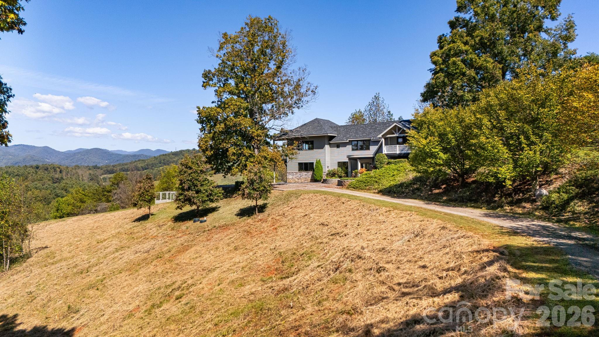 Recent price adjustment is now well below market value! Exceptional 20 plus acre Estate in Scenic Mars Hill, NC Discover this stunning estate nestled in Madison County NC, known as "The Jewel of the Blue Ridge Mountains." Started in 2000 with a small 990 sq ft cabin, then the home was expanded and newly constructed in 2017 to the present home and floor plan. Enjoy breathtaking 270-degree long-range mountain views and spectacular sunsets. The meticulously manicured grounds feature a small pasture and a vibrant array of flowers that attract pollinators. With NO HOA and NO restrictions, you have the freedom to embrace country living and raise chickens for a fresh egg breakfast, right on your choice of two balcony decks! A small, fenced coop behind the house has previously served as a garden for fresh herbs and berries. Land is surveyed for a small development of 10 homes. There are numerous potential home sites identified in the survey, perfect for building a separate guest quarters or a short-term rental if desired. The current home expansion was completed in 2017 with a finished heated and cooled area of 3391 sq ft. When combined with the decks, garage, garage utility flex space, and all non-HLA areas, the home has a total of 5197 sq ft. A 1/4-mile driveway ensures privacy, and if desired, a paved road for your luxury or classic vehicles can be easily installed, but is not needed, a paving estimate is available. Any car can access the home easily. Conveniently located just 8 minutes from Mars Hill Ingles grocery store and college, Hot Springs 35 minutes, 17 minutes to Weaverville Publix, 26 minutes to downtown Asheville, and 40 minutes to the Asheville airport. Escape to the serene beauty of the Western NC Mountains and claim your own generational private estate. Experience peace, tranquility, and the stunning four-season colors of this expansive mountain view from your private, custom Trex wood terrace, with truly breathtaking year-round views! Make this estate your “Jewel of the Blue Ridge Mountains”.  Please review the extensive feature list, which includes High-Quality construction throughout the home. A Matterport home tour link is also available. The mountains are calling and I must go! Schedule your showing soon!