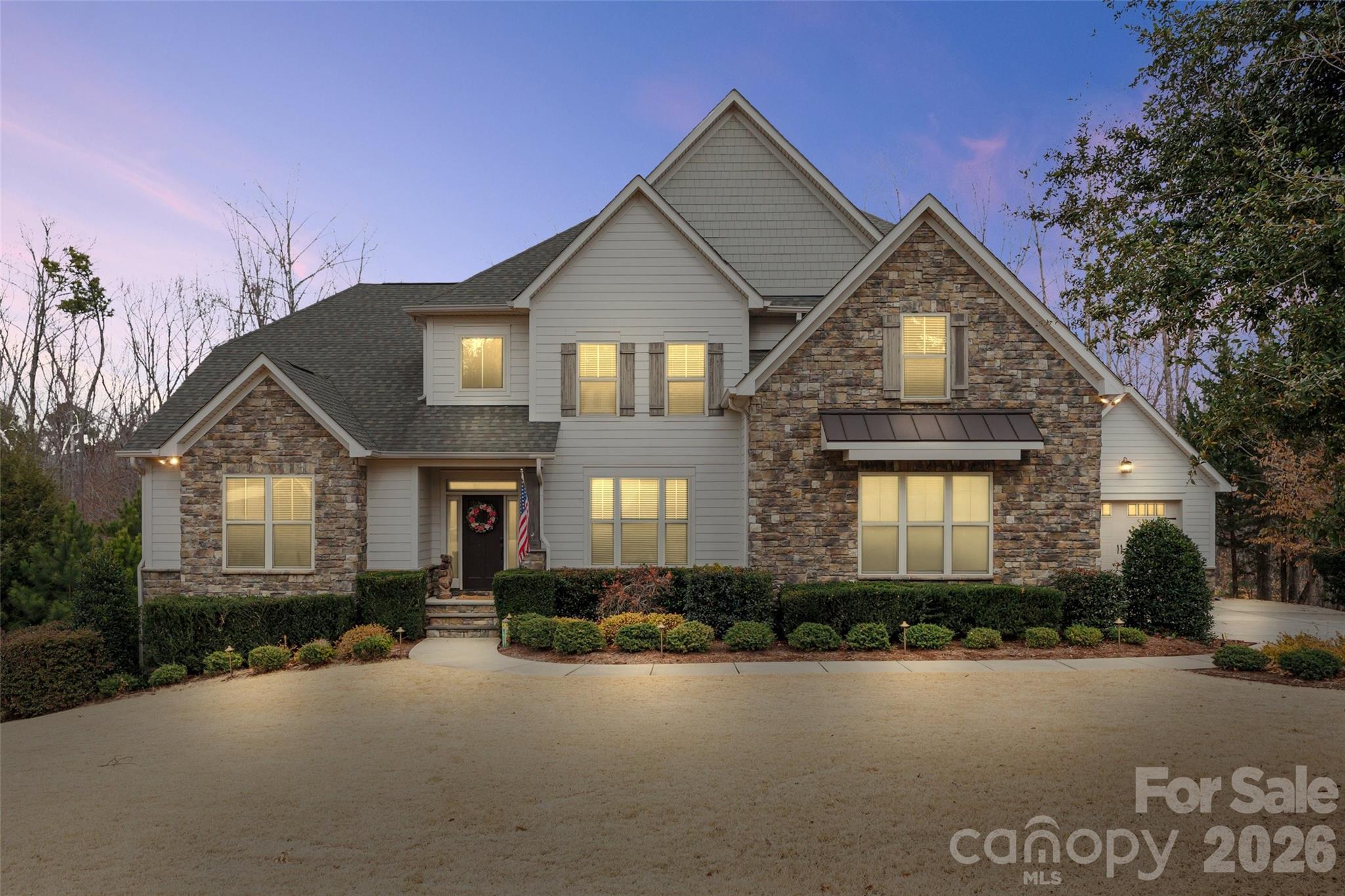 Tucked away on a private, wooded 1.4-acre lot with beautiful seasonal lake views, this exceptional property offers luxury living, resort-style amenities, and unmatched versatility all while being centrally located to Lake Wylie living and conveniently situated near all that Charlotte has to offer. From the moment you arrive, you’ll appreciate the rare combination of privacy, craftsmanship, and thoughtful upgrades that make this home an entertainer's dream with plenty of room for family and guests and even includes a 2nd Living Quarters.

The spectacular backyard is a professionally designed retreat created for both entertaining and everyday enjoyment. At the center is an impressive 18,000-gallon heated saltwater pool, enhanced by a soothing waterfall and integrated hot tub. Expansive paver decking surrounds the pool, providing ample space for lounging and gatherings. The outdoor kitchen is fully equipped with a grill and smoker, making al fresco dining effortless. Nearby, a hand-hewn natural boulder gas fire pit creates a dramatic focal point and the perfect setting for relaxing evenings under the stars.

Inside, the home continues to impress with hardwood floors and high-end finishes throughout. The main kitchen features an open concept, oversized island, dining area with stunning views, cabinets galore, GE Profile appliances, all complemented by custom California Closets organization systems in the primary bedroom closets and the kitchen pantry, blending style with function.

A standout feature of this property is the fully equipped second living quarters, ideal for multigenerational living, long-term guests, or fun family moments. This private space includes its own full kitchen, living room, dining area, primary bedroom and ensuite bathroom, offering comfort and independence without compromise.

Practicality meets luxury with an abundance of thoughtful upgrades. For ultimate convenience and peace of mind, the home includes two separate laundry rooms each with their own washer and dryer, a Generac whole-house generator, surround sound, two refrigerators, two gas ranges and a comprehensive security system with five outdoor cameras.

Boat owners, car enthusiasts, and hobbyists will appreciate the secondary garage, which is 28 feet deep and features an oversized 9-foot-high by 10.5-foot-wide door ideal for boat storage, additional vehicles, or a workshop. 

With generous acreage, seasonal lake views, resort-style outdoor living, and an incredible list of upgrades, this property offers a rare opportunity to own a private retreat that feels like a vacation destination all while enjoying the comforts of home with close proximity to Charlotte (only 30 minutes to uptown & the airport). This is a must see home!