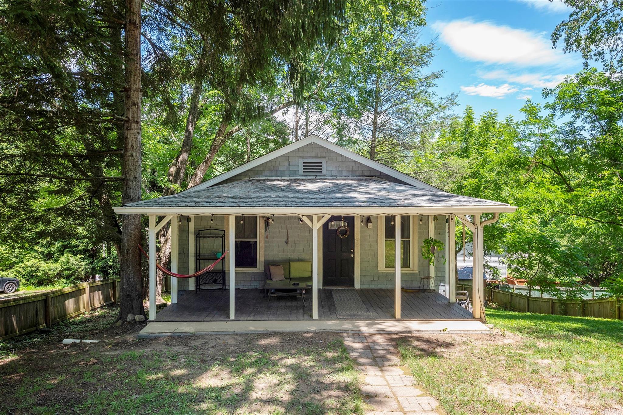Welcome to 14 Border Street, a classic 1940's bungalow tucked into one of Black Mountain's established neighborhoods. Set on a beautiful 0.23 acre fenced lot with mature hardwoods, this home offers timeless character, a peaceful setting, and endless potential.
Enjoy quiet mornings on the front porch with a cup of coffee, birds singing and fresh mountain air.  You may never want to leave the property's inviting yard. New wood fencing keeps pets safe and your garden too.  
 Meet up with friends for a bite to eat in downtown Black Mountain conveniently 5 minutes away or cruise on down to Asheville to take in a show.  
This bungalow is full of warmth and history. The seller replaced the roof in 2021 and added new insulation. Additionally they had exterior foundation water proofing done and drains installed for rain protection. Affordably priced and ideally located, opportunities like this in Black Mountain don't come along often.