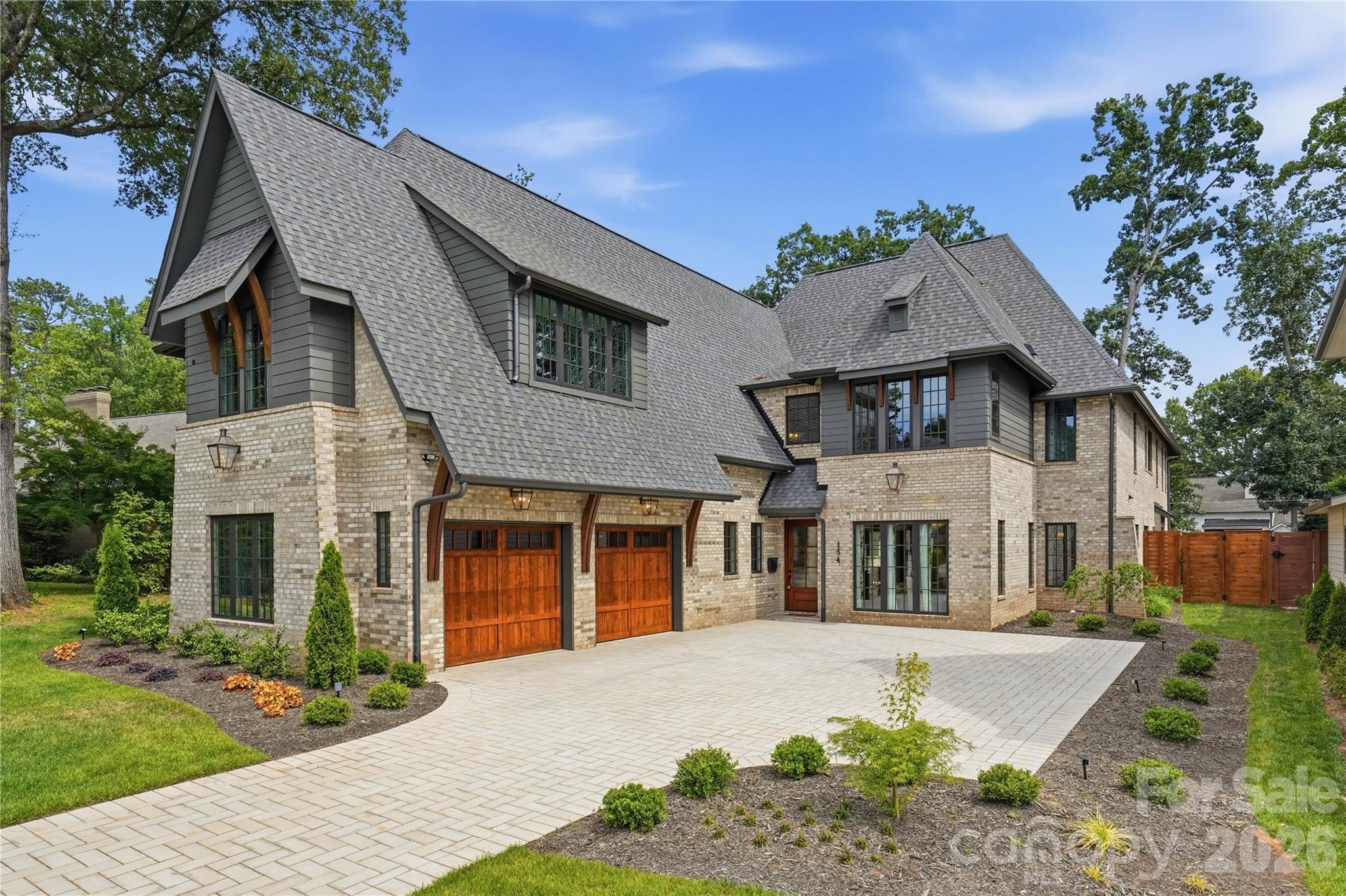 154 N Canterbury Rd is a showstopping luxury estate by Maverick Building that seamlessly blends elevated design, thoughtful functionality, and resort style living in the heart of Cotswold. This exceptional 6 bedroom, 7.5 bath new construction home was designed for both everyday comfort and unforgettable entertaining. The outdoor living experience is truly unmatched, featuring a pool and hot tub, a fully equipped pool cabana with a kitchen and oversized island, a full outdoor bath with a changing area, and an outdoor shower. Three covered porches overlook the pool and create a private retreat, while the expansive yard offers ample space for recreation, relaxation, and entertaining. Inside, curated designer finishes and refined architectural details elevate every space. The grand living room showcases 11-foot ceilings with exposed wood beams and a striking cast stone fireplace. A walk in wine room with a steel framed glass entry door and custom cabinetry serves as a sophisticated focal point for entertaining.
The primary suite is a true retreat, designed to feel like a luxury resort. Enjoy a private covered terrace overlooking the pool, a spacious sitting area, and a custom coffee and wine bar. The spa-inspired bath features a large walk-in shower, soaking tub, and an extraordinary custom closet complete with inset lighting, glass front cabinetry, soft close drawers, and a Taj Mahal quartzite waterfall island. A junior primary suite on the main level provides an ideal private space for guests, complete with dual vanities and a soaking tub. Upstairs, the expansive bonus room offers incredible flexibility with built-in seating, a wet bar, full bath, and an open layout that is perfect for a media room, lounge, playroom, or additional guest retreat. Every inch of this home reflects intentional design. From the custom cabinetry and flooring selections to the lighting, color palette, and designer wallpaper, each element was carefully chosen to create a cohesive and elevated aesthetic throughout. Situated on one of Cotswold's most sought after and walkable streets, surrounded by luxury new construction and estate homes, this prime location offers convenient access to SouthPark, Uptown, premier private schools, shopping, dining, and everything that makes Cotswold one of Charlotte's most desirable neighborhoods.