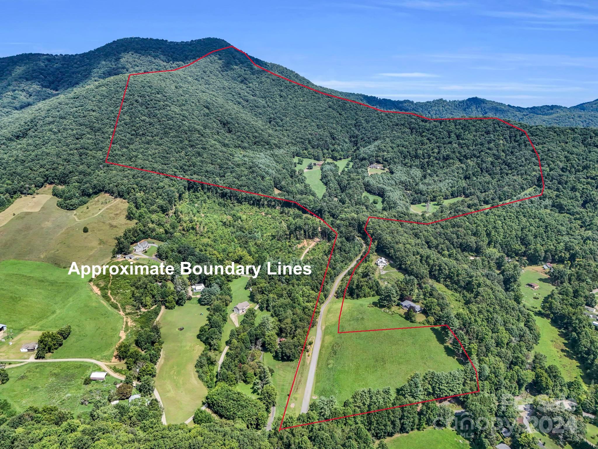 Flood Zone X (Minimal Flood Risk). Incredible 240 acre farm in Buncombe County with breathtaking mountain views for miles, including Mt. Pisgah! This meticulously maintained property has approximately 1.5 miles of paved driveways, 6+ miles of maintained trails for hiking/horseback riding/ATV use, a 17-stall barn with tack room, a 3-BR barn apartment, hay storage, a pond, a pole barn, a 3562 square foot main house, and a mix of cleared pastures and woods. The main house has an elevator, 2 fireplaces, large bedrooms, and some of the best views in Western North Carolina from the covered porch and main level rooms. The barn apartment has a 2-car garage, 1856 square feet of recently renovated living space, and amazing views from the deck. There are multiple building sites that will also have spectacular views. A rare offering for such a large tract so close to Asheville, this private estate is ideal for equestrian use, events, hunting, and more. Gated road for complete privacy and security.
