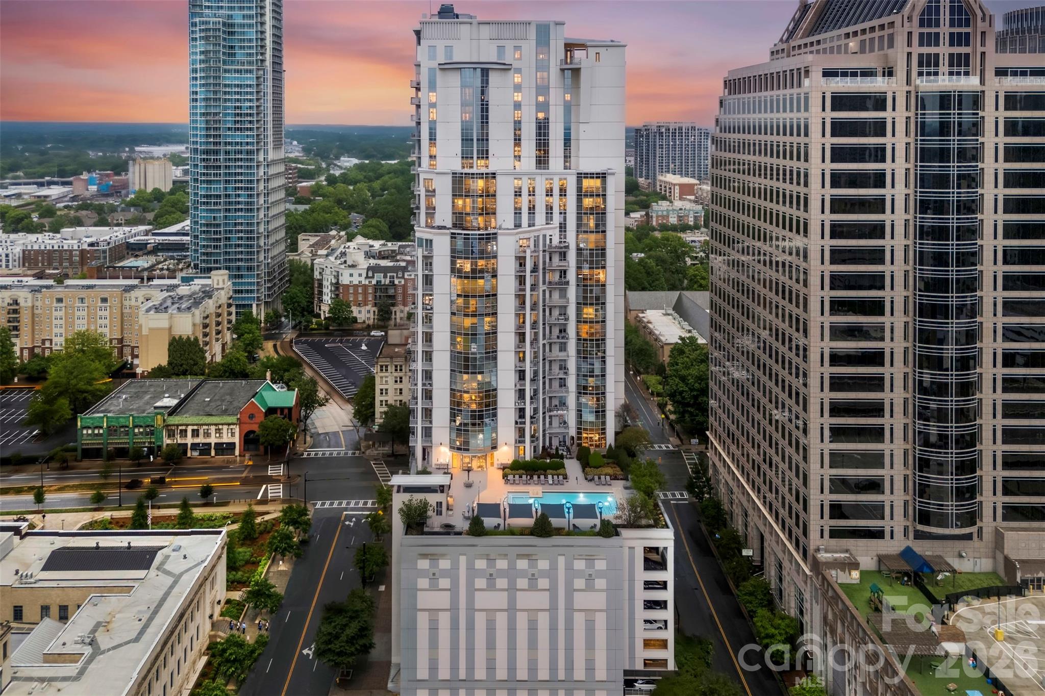 Experience the pulse of Uptown Charlotte from this sun-drenched corner of the Trademark building. Positioned just steps from Romare Bearden Park and Truist Field, this residence trades "cookie-cutter" for character. The layout feels remarkably expansive, framed by floor-to-ceiling glass that captures the skyline at every turn. Recent high-end refinements include quartzite surfaces and a custom-built primary suite closet that’s a total game-changer. Whether you’re working from the integrated view-side desk or hosting friends at the rooftop pool, this home serves as a sleek sanctuary in the heart of the city.