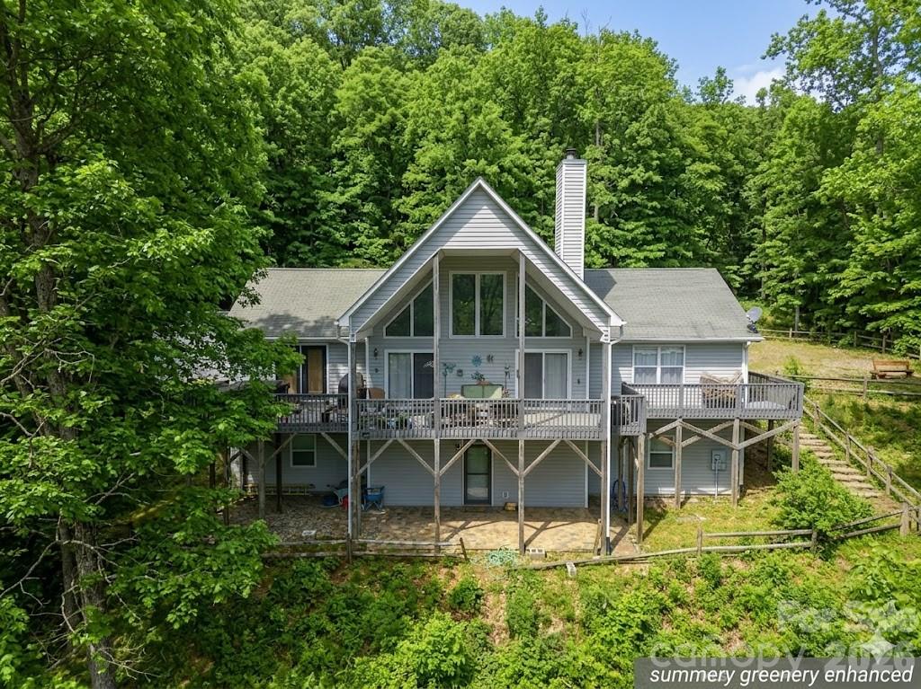 SIGNIFICANT PRICE IMPROVEMENT! Now offered at $799,000, this beautifully maintained mountain retreat combines the ease of one-level living with the flexibility today's buyers are seeking. Set on 1.8 acres in the desirable Walnut Creek community, the home captures breathtaking long-range mountain views, including a distant glimpse of the Blue Ridge Parkway.

Designed with gathering in mind, the main level offers comfortable everyday living with the primary suite, laundry, open living spaces, and additional bedrooms all on one floor. Vaulted ceilings, a dramatic wall of windows, hardwood floors, and a stunning stone wood-burning fireplace create a warm and inviting atmosphere, while the well-appointed kitchen features quartz countertops and a custom island designed for both entertaining and daily life.

The primary suite opens directly to the expansive deck and hot tub, where mornings begin with mountain sunrises and evenings end beneath star-filled skies. The spa-inspired bath includes radiant heated floors, a whirlpool tub, and separate shower.

The fully finished lower level provides exceptional flexibility with its own entrance, kitchenette, bedroom, bath, and laundry area—ideal for extended family, visiting grandchildren, private guest accommodations, or potential rental opportunities.

With limited exceptions, most furnishings are negotiable in a separate bill of sale, offering a rare opportunity to purchase a largely turnkey mountain home featuring quality furnishings from trusted names such as Thomasville and Broyhill.

Located approximately 15 minutes from Waynesville, this special property offers the peaceful beauty of mountain living with convenient access to shopping, dining, outdoor recreation, and the many cultural experiences that make Western North Carolina so desirable. Seller's next home is nearing completion, creating an exceptional opportunity for buyers ready to make their move.