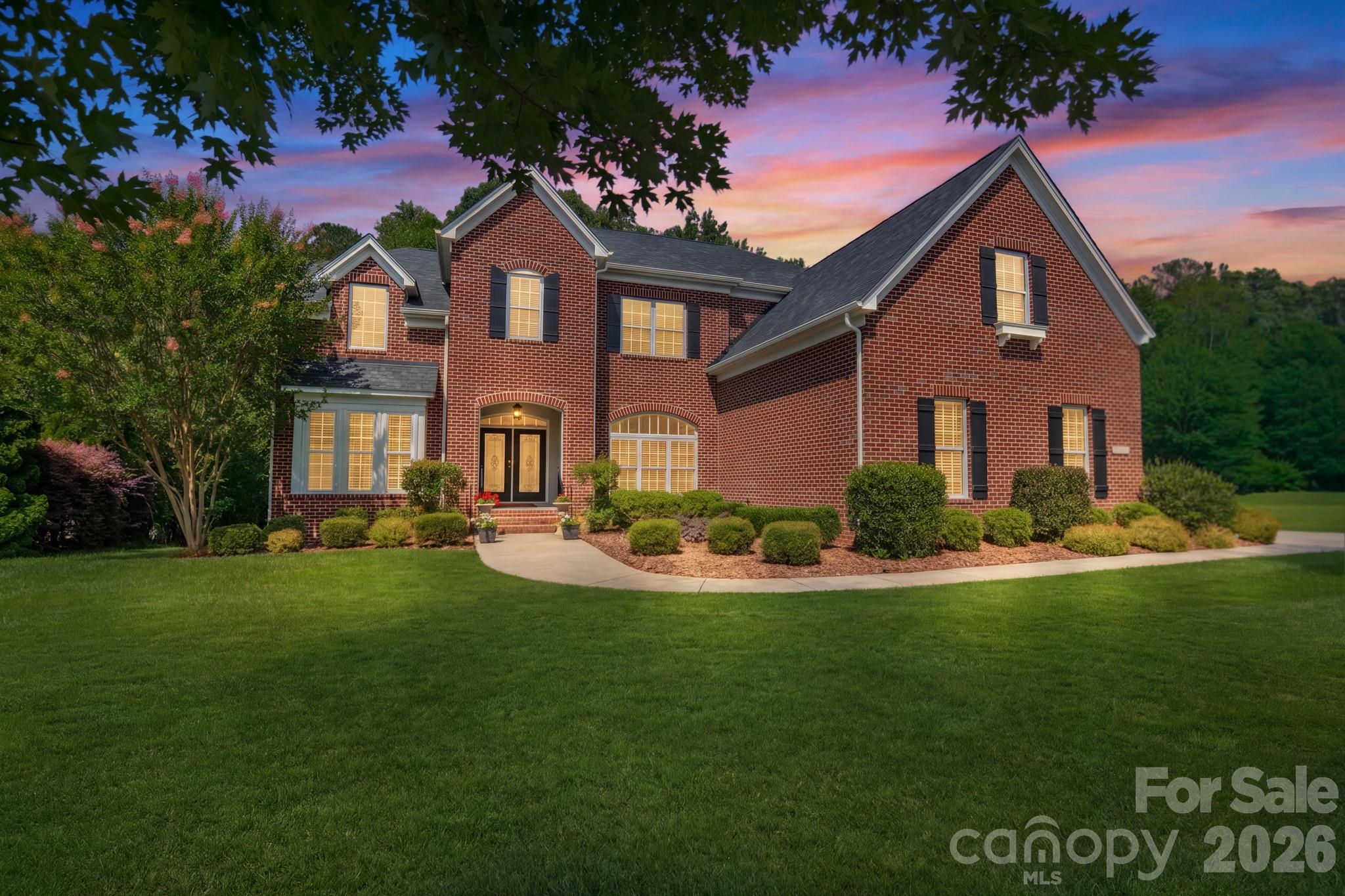 Nestled on a desirable cul-de-sac street within the Estates enclave of Hollister, this immaculate full-brick home offers timeless design, thoughtful updates, and an exceptional lifestyle. Residents enjoy access to exceptional community amenities, including a resort-style pool, clubhouse, tennis courts, sport court, playground, and scenic nature trails, all while being zoned for top-performing Weddington schools.

A grand double-door entry welcomes you into a dramatic two-story foyer. Gleaming hardwood floors, refined millwork, updated lighting, fresh interior paint, and brand-new carpet create a warm and elevated atmosphere throughout. Designed for both entertaining and everyday living, the open floor plan features a spacious dining room, a vaulted flex room, and an inviting family room with 10-foot ceilings, exceptional natural light throughout the space, built-ins, integrated speakers, and a gas fireplace with marble surround.

The well-appointed kitchen offers abundant cabinetry, an expansive center island, built-in appliances, a gas cooktop, and a spacious breakfast area highlighted by a tray ceiling detail. The main-level primary suite provides a private retreat with a spa-inspired bath and an impressive walk-in closet featuring custom organization, a center island, and washer/dryer connections.

Upstairs you'll find three spacious secondary bedrooms, including an ensuite bedroom and another with an adjoining flex space, plus a media room, expansive bonus room, upgraded baths with marble countertops, and a dedicated laundry room. Additional highlights include a mudroom, walk-in attic storage, three-car side-load garage with EV charging outlet, new water heater, and brand-new roof. Relax on the covered rear porch overlooking a private wooded backyard.

Beautifully curated and impeccably maintained, this home offers refined design, privacy, and everyday livability. Ideally located near shopping, dining, and major employment centers, it delivers an exceptional lifestyle in one of the area’s most sought after communities.